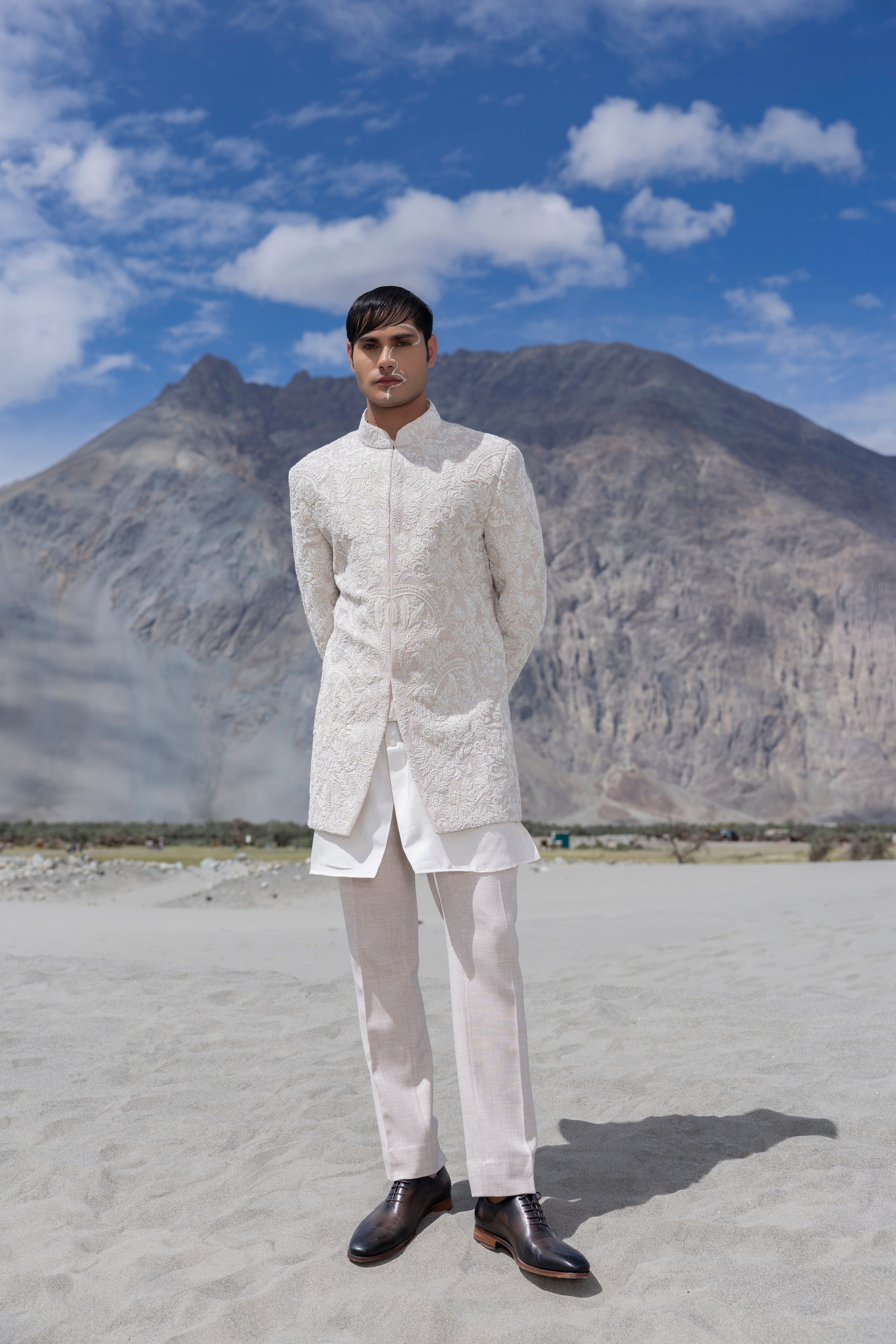 Baby pink hand-embroidered indowestern paired with a short ivory kurta and matching pants.