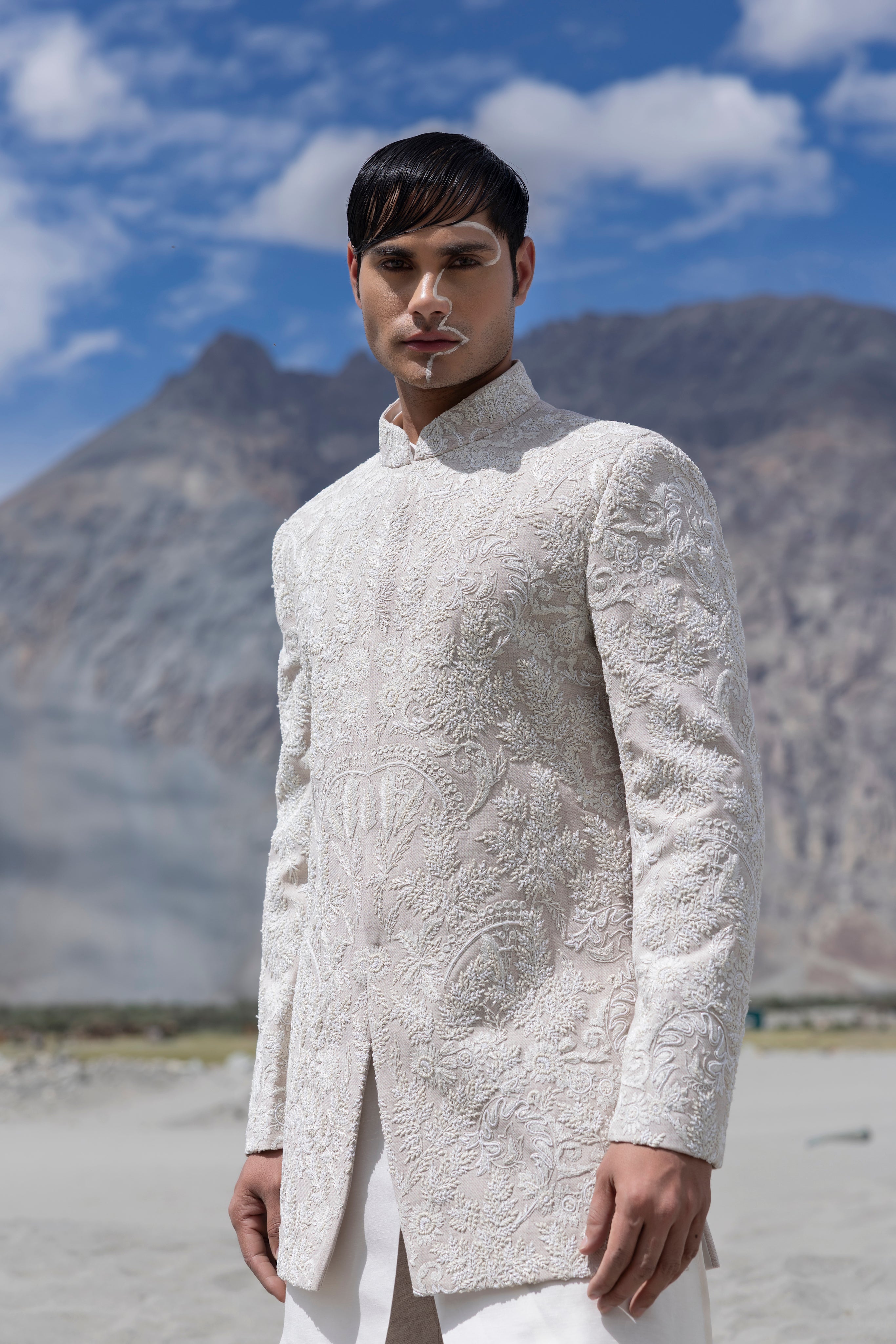 Baby pink hand-embroidered indowestern paired with a short ivory kurta and matching pants.