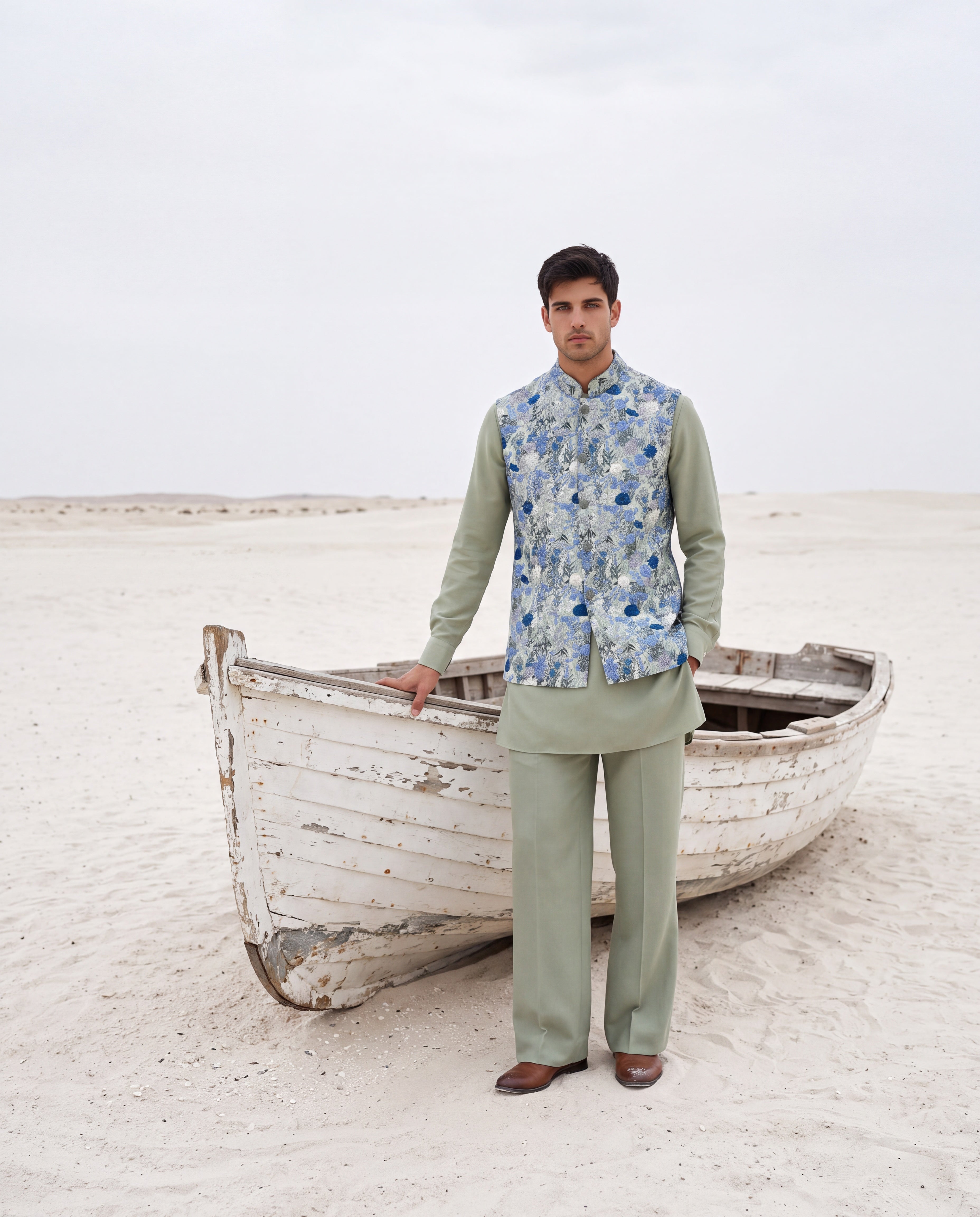 Pista green crepe waistcoat with multi-coloured floral hand-embroidery paired with a matching crepe kurta and aligadhi pants.