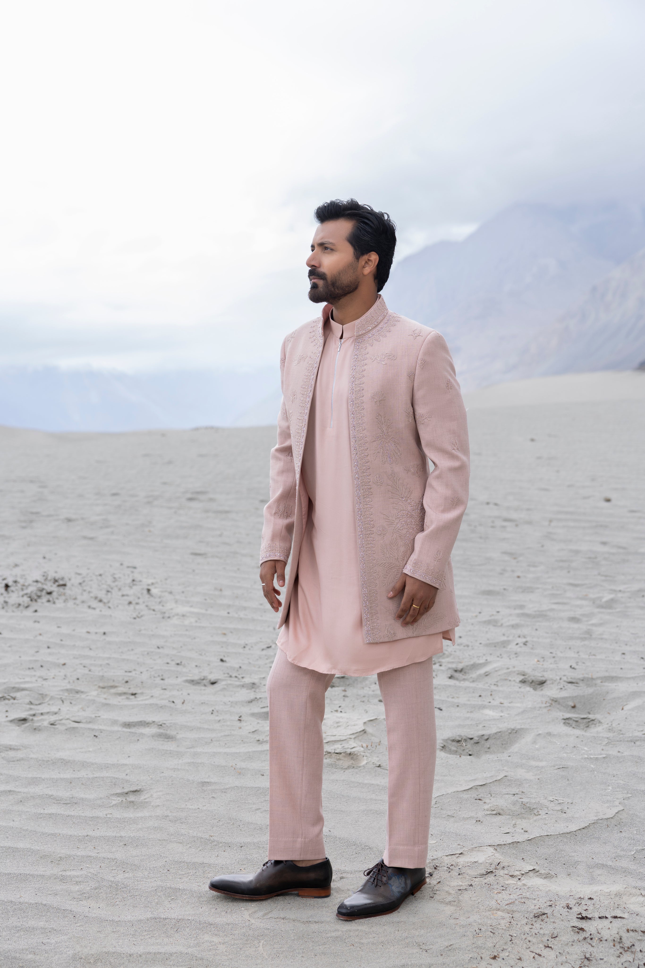 Pink  open long indowestern jacket with hand-embroidered motifs paired with a zippered  kurta and pants.