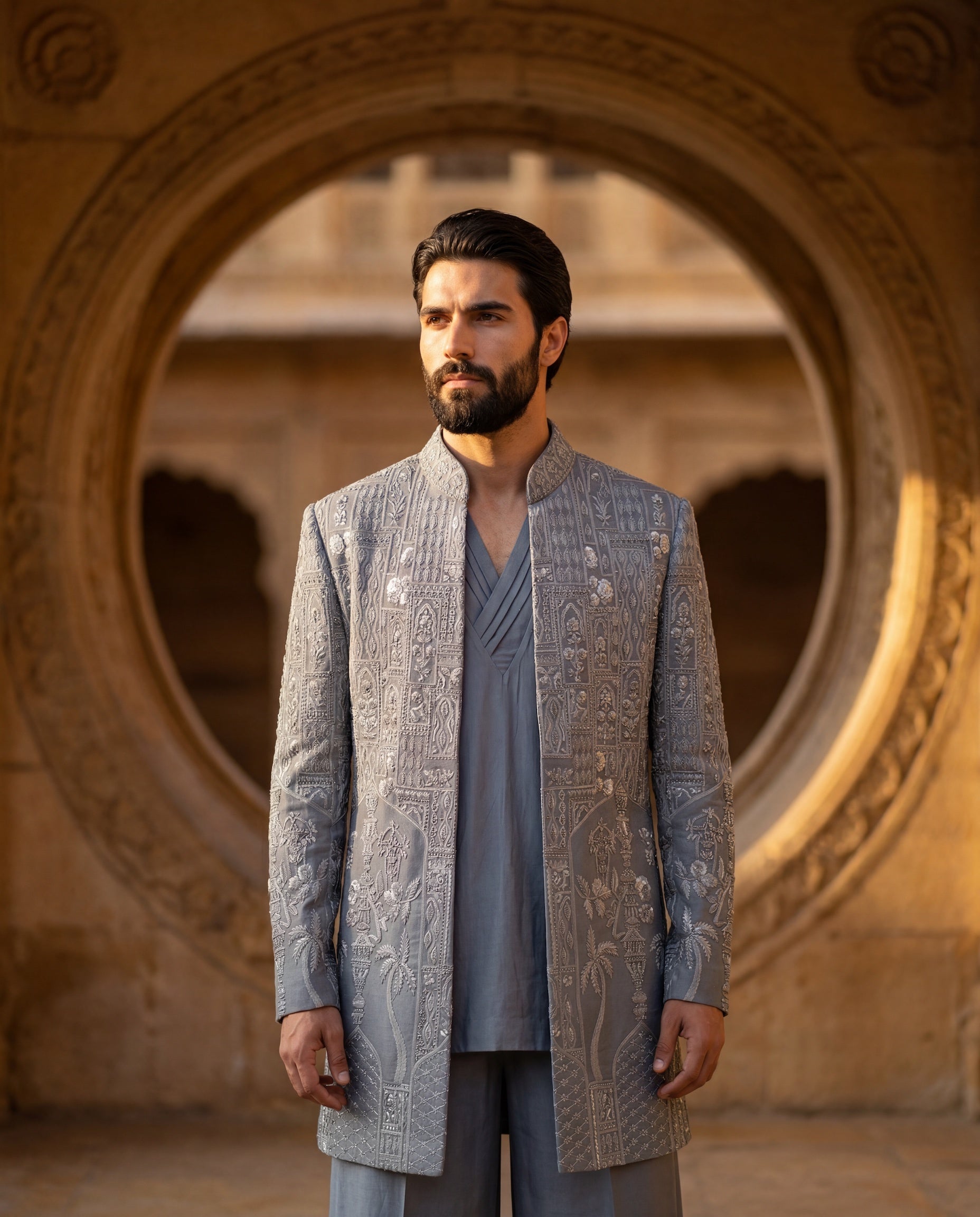 Grey Linen rayon Indo-Western jacket with monoton embroidery detailing, paired with a pleated neckline kurta and matching linen rayon pants.
