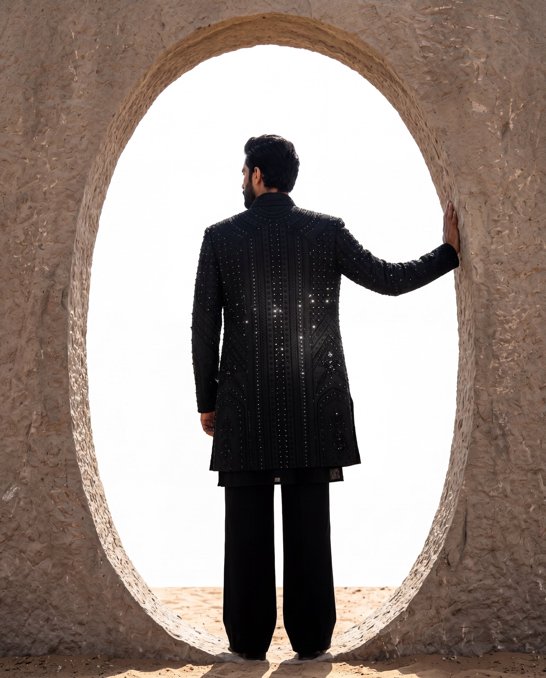 Black embroidered twill knit Indo-Western jacket with intricate detailing, paired with a Banarasi silk kurta and matching pants.