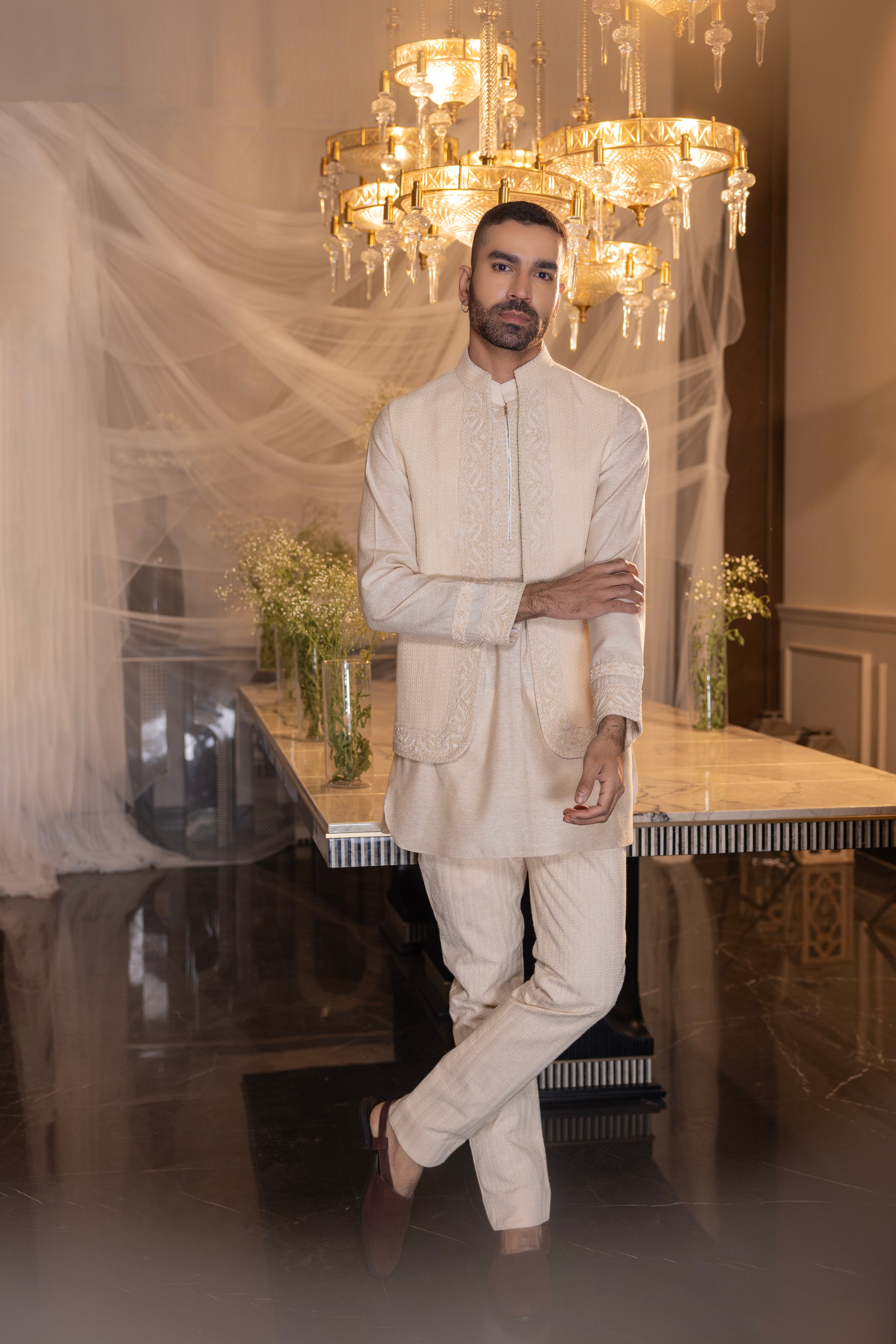 Cream waistcoat with intricate montone hand-embroidery paired with an embroidered kurta and crochet pants.