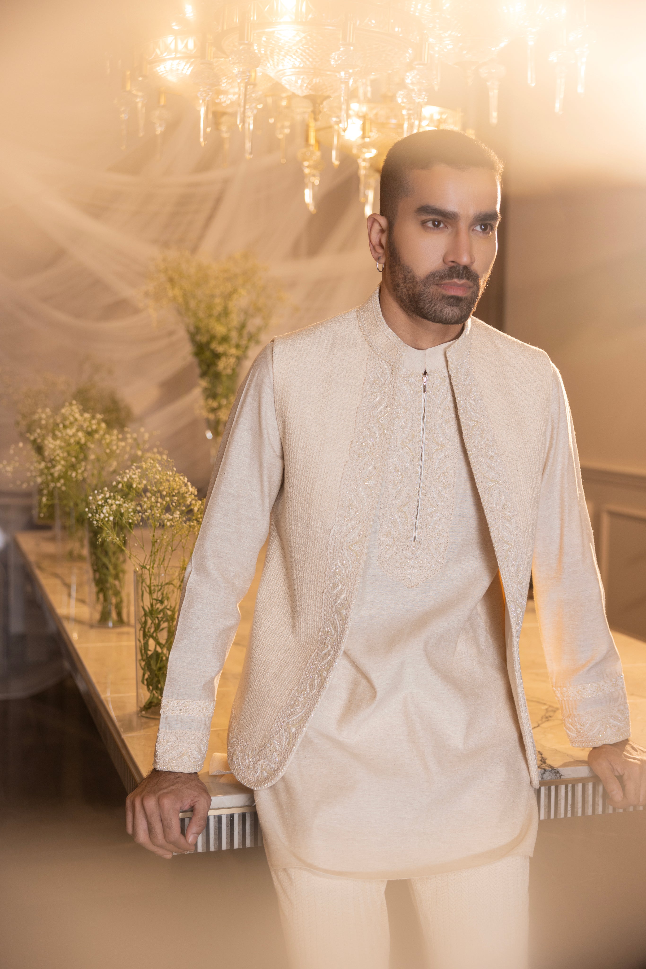 Cream waistcoat with intricate montone hand-embroidery paired with an embroidered kurta and crochet pants.