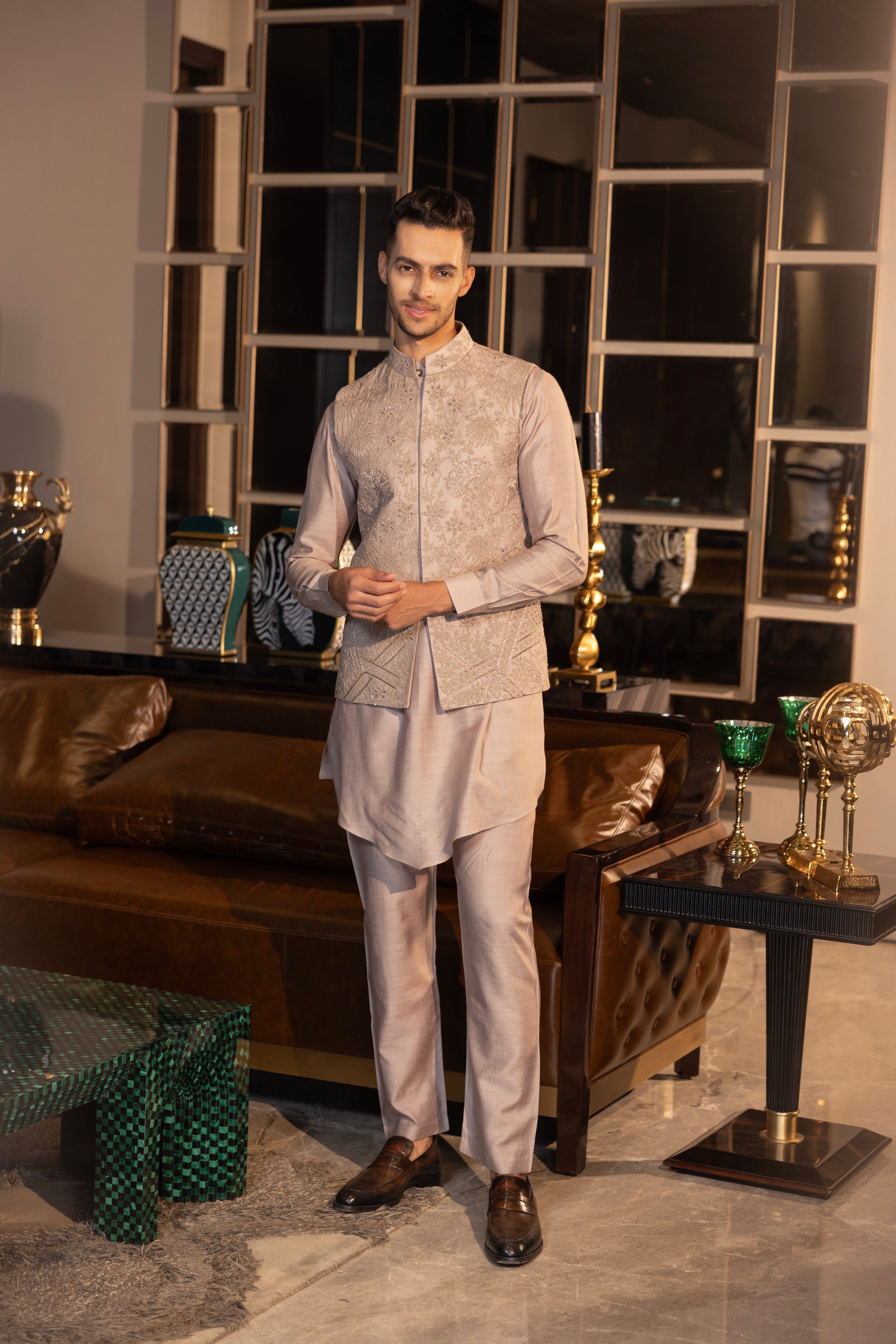 Mouse colour waistcoat with intricate montone hand-embroidery paired with a matching kurta and aligadhi set.