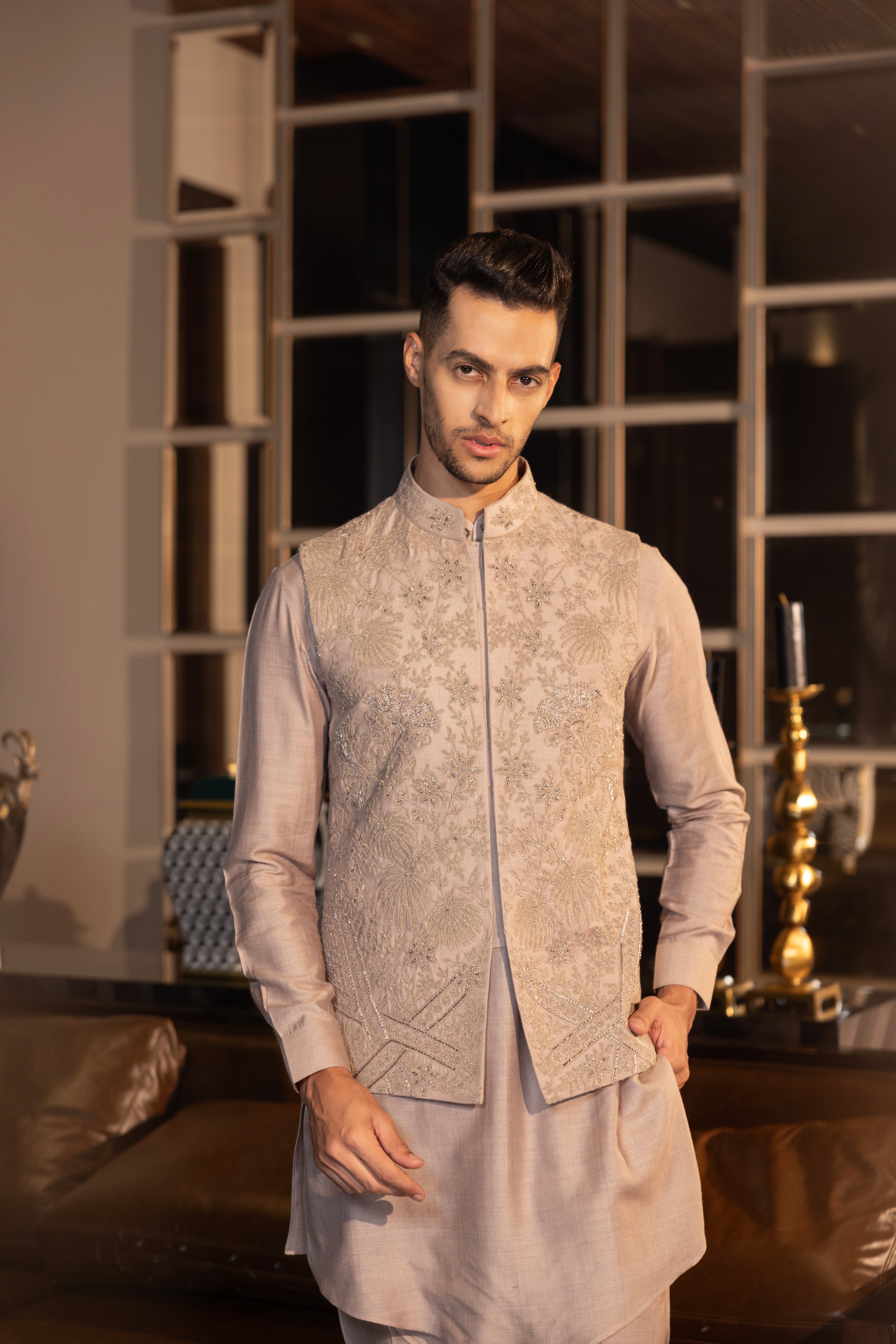 Mouse colour waistcoat with intricate montone hand-embroidery paired with a matching kurta and aligadhi set.