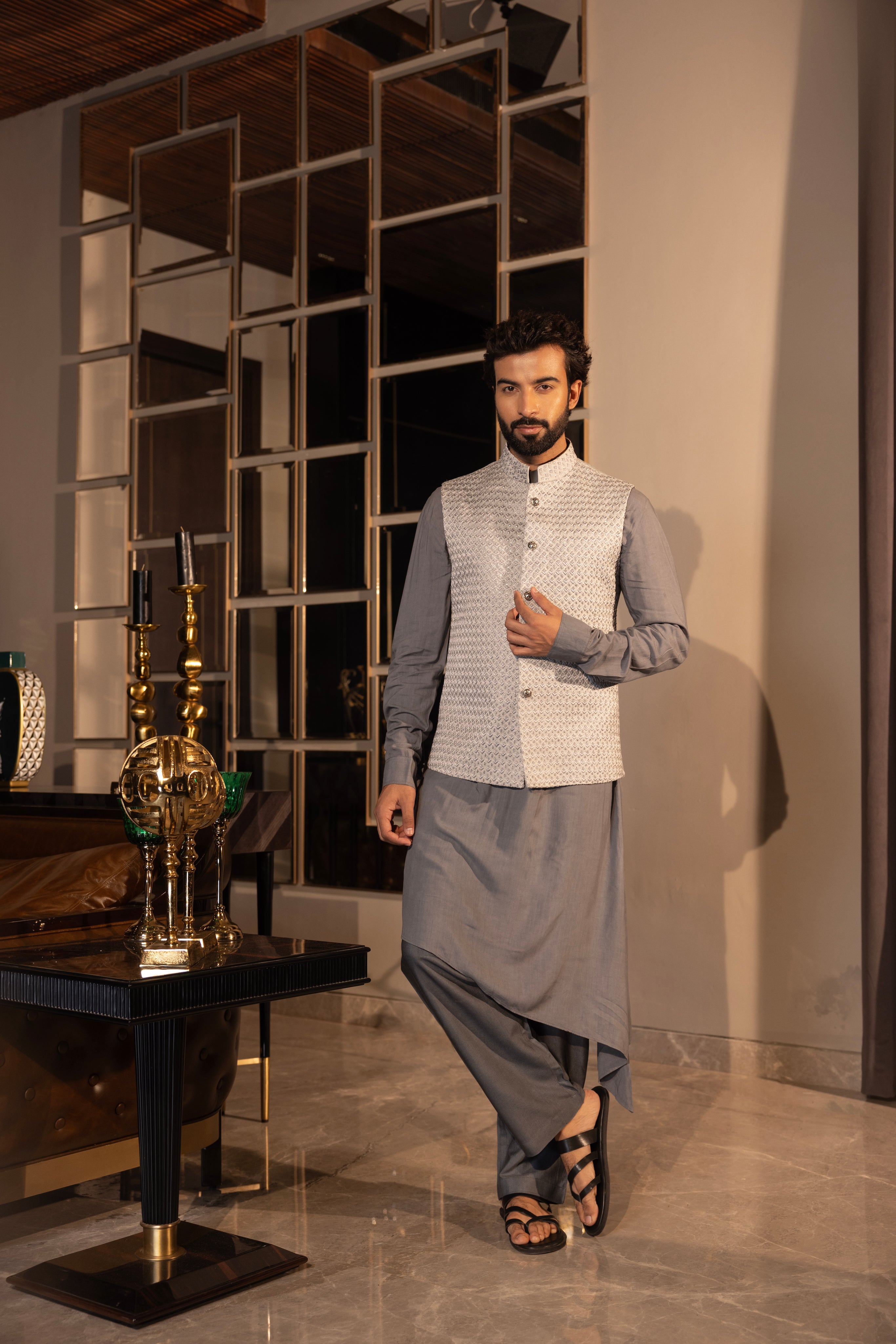 Grey hand-embroidered jacquard waistcoat paired with an asymnetrical kurta and & matching aligadhi set.