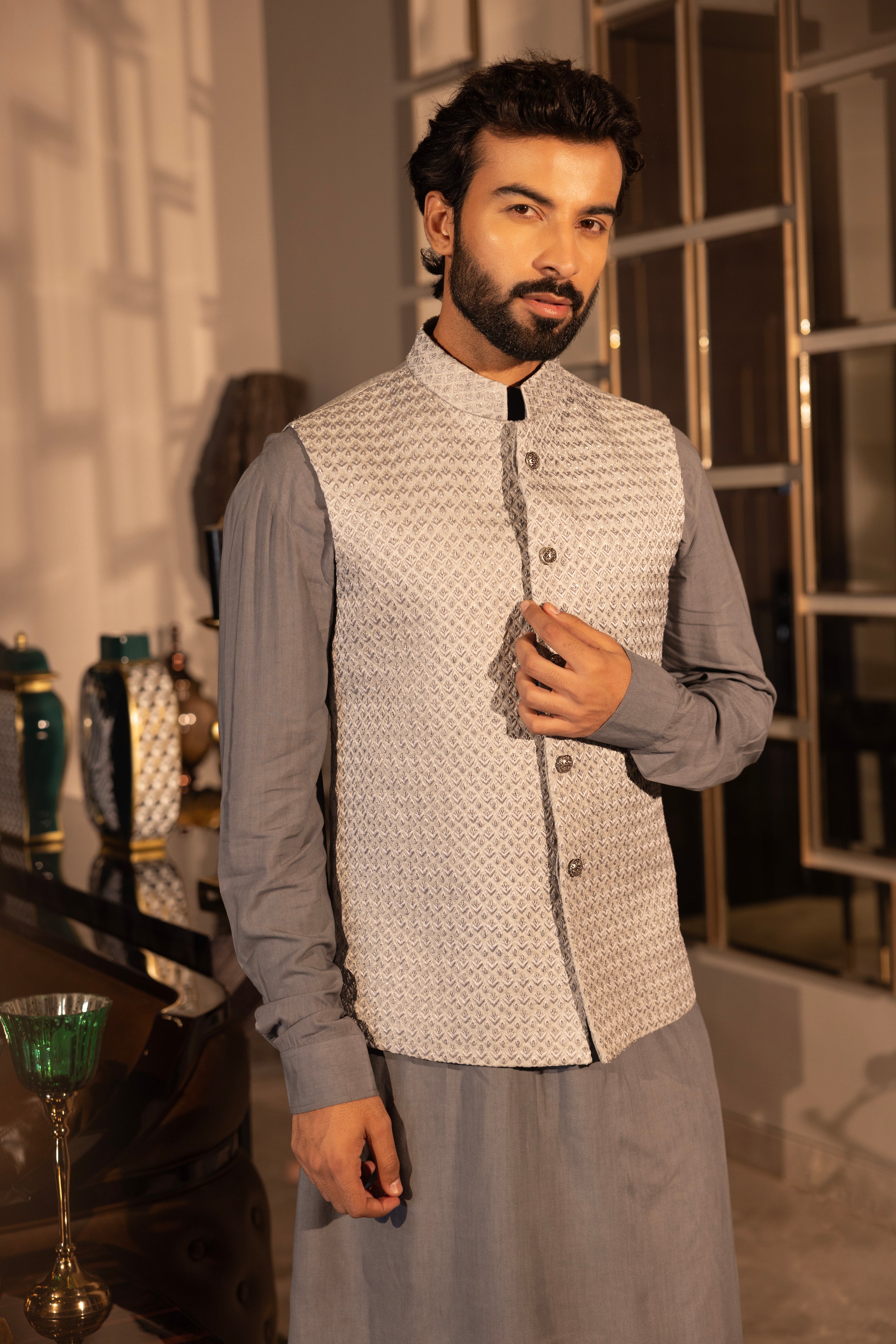 Grey hand-embroidered jacquard waistcoat paired with an asymnetrical kurta and & matching aligadhi set.