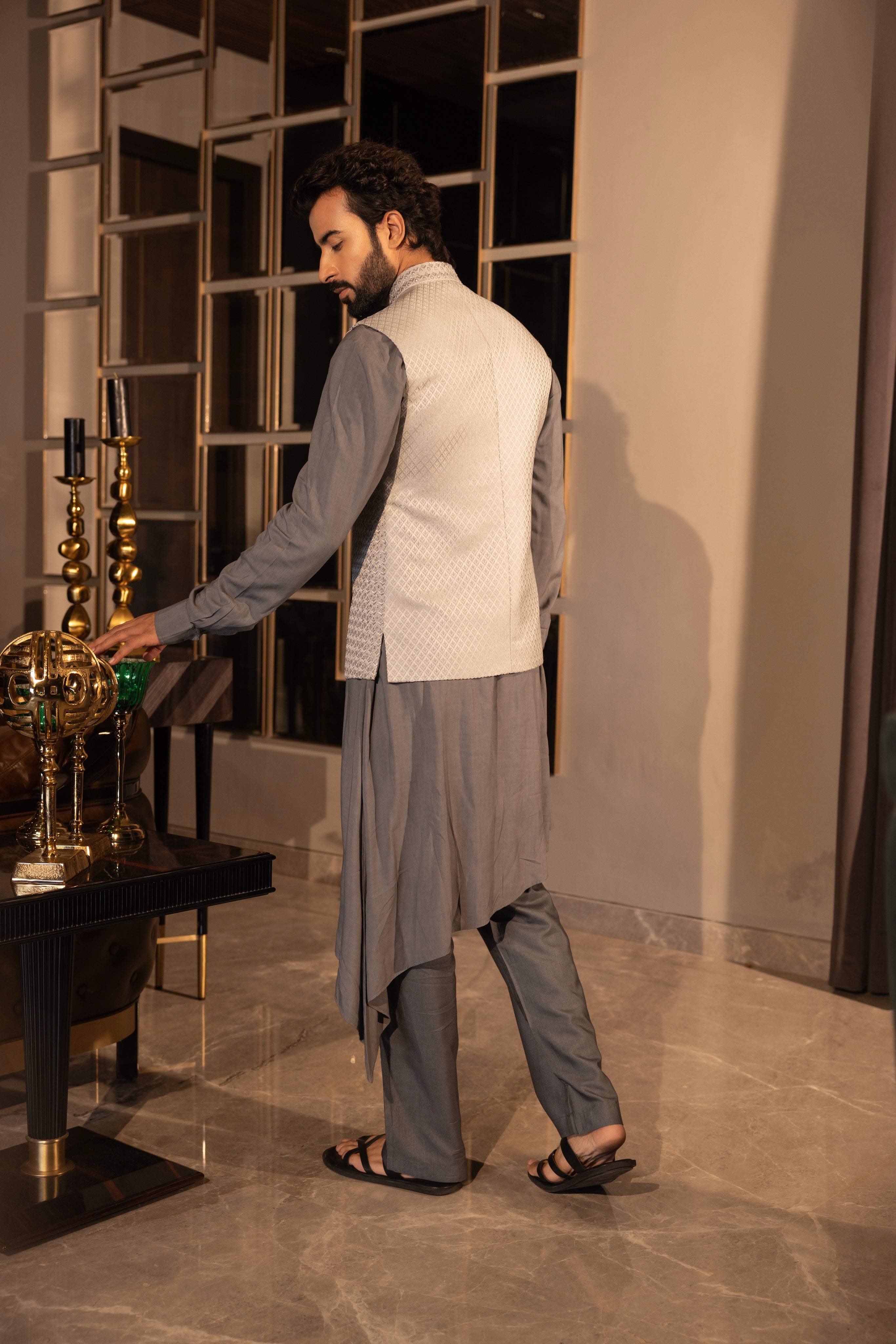 Grey hand-embroidered jacquard waistcoat paired with an asymnetrical kurta and & matching aligadhi set.