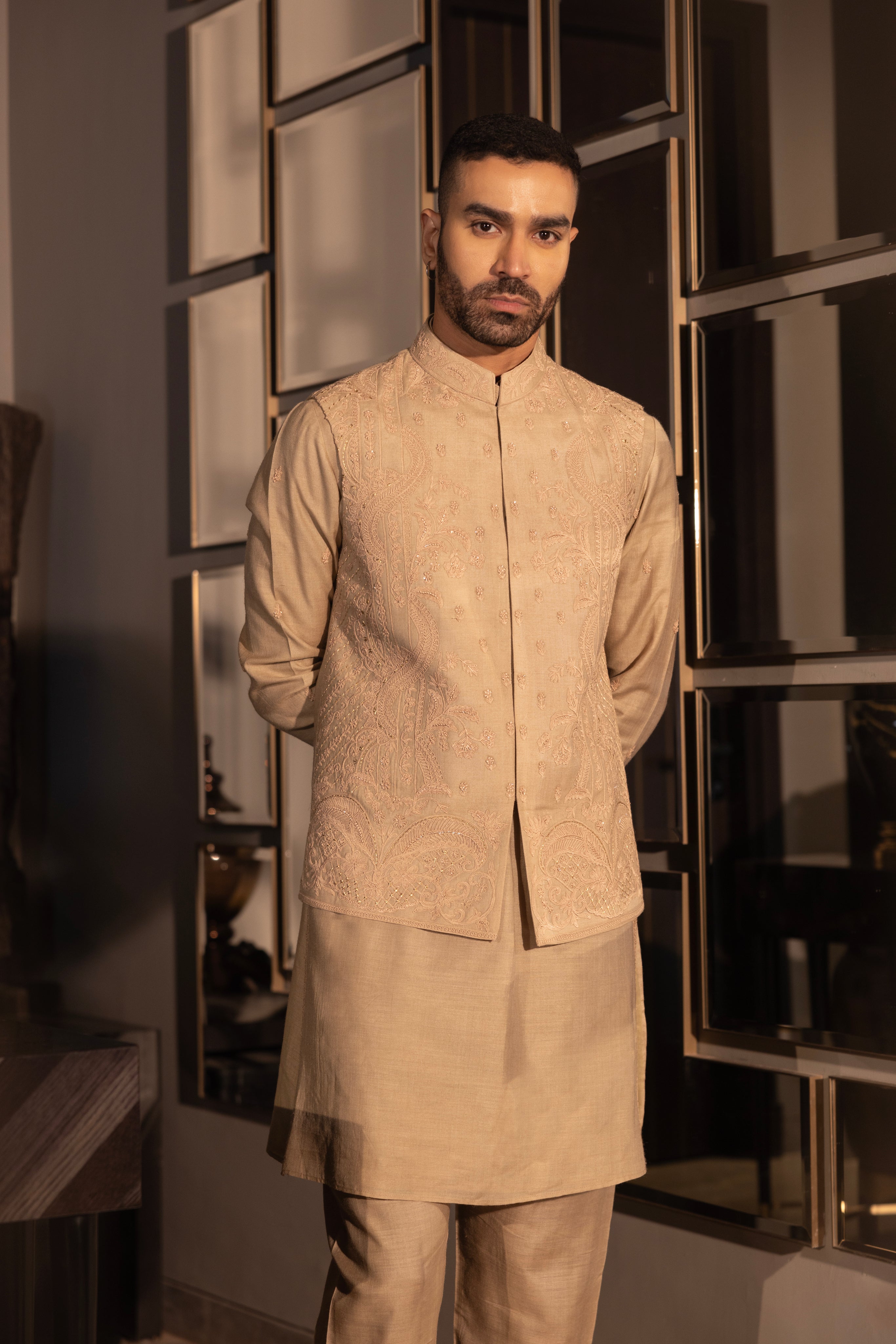 Khakhi waistcoat with intricate montone hand-embroidery paired with a matching kurta and aligadhi set.