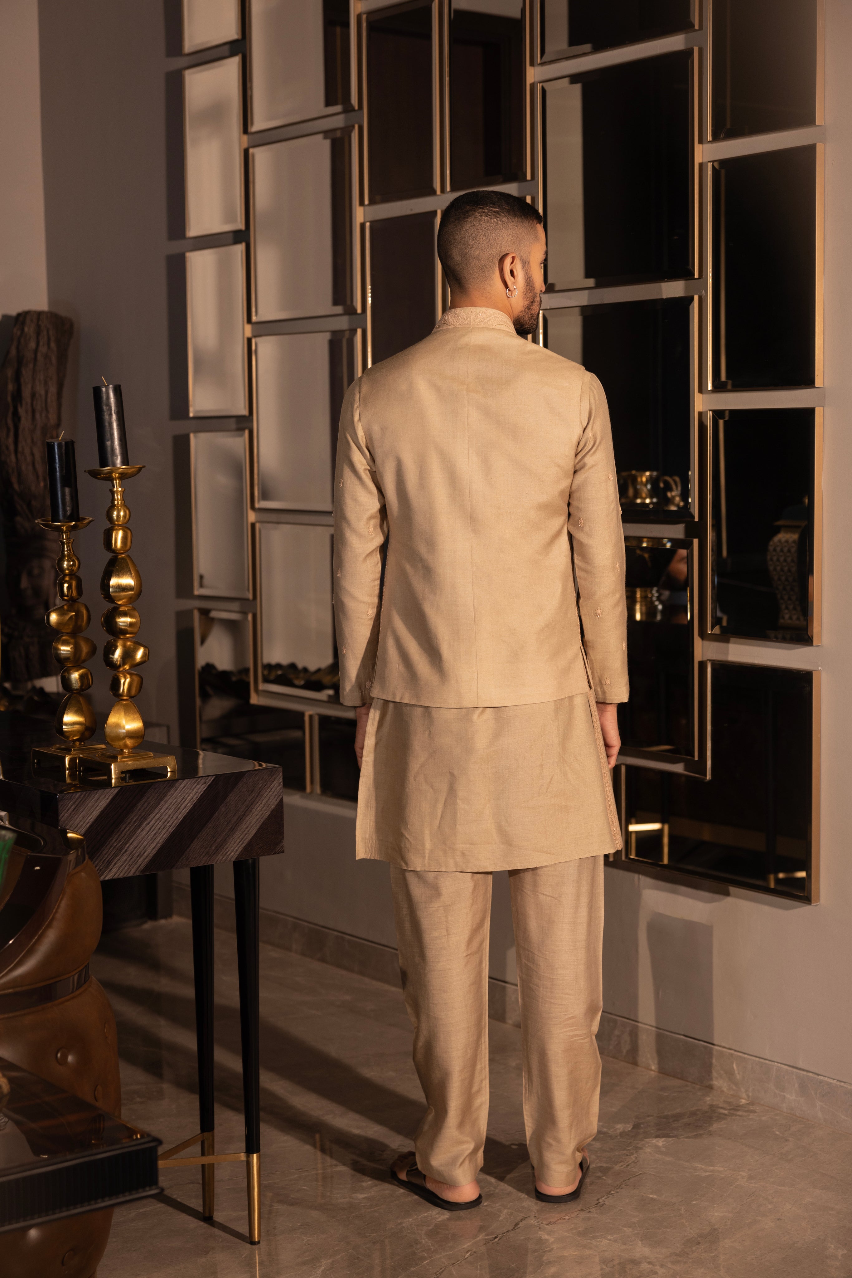 Khakhi waistcoat with intricate montone hand-embroidery paired with a matching kurta and aligadhi set.