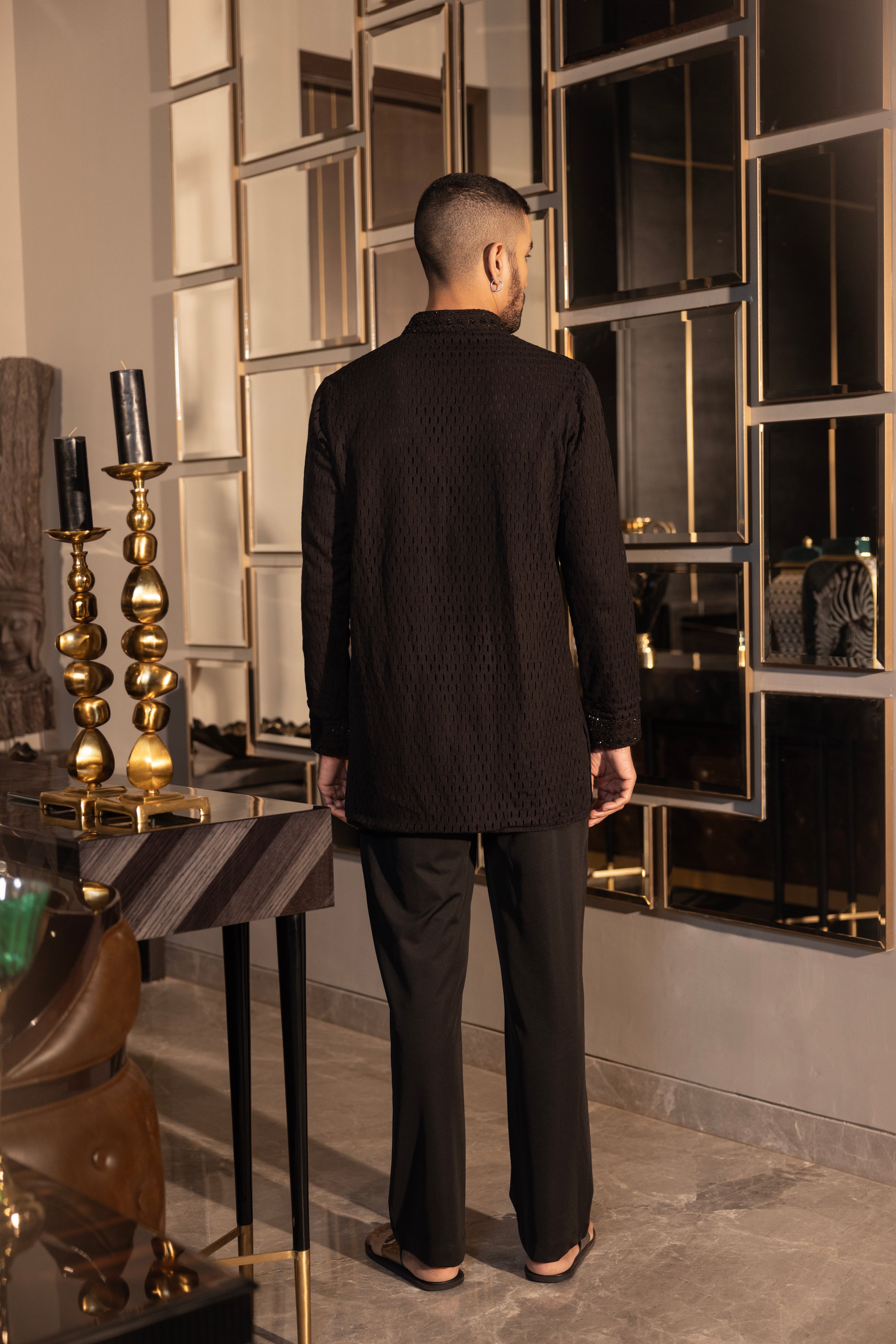 Hand-embroidered black crochet short kurta paired with a matching aligadhi set.