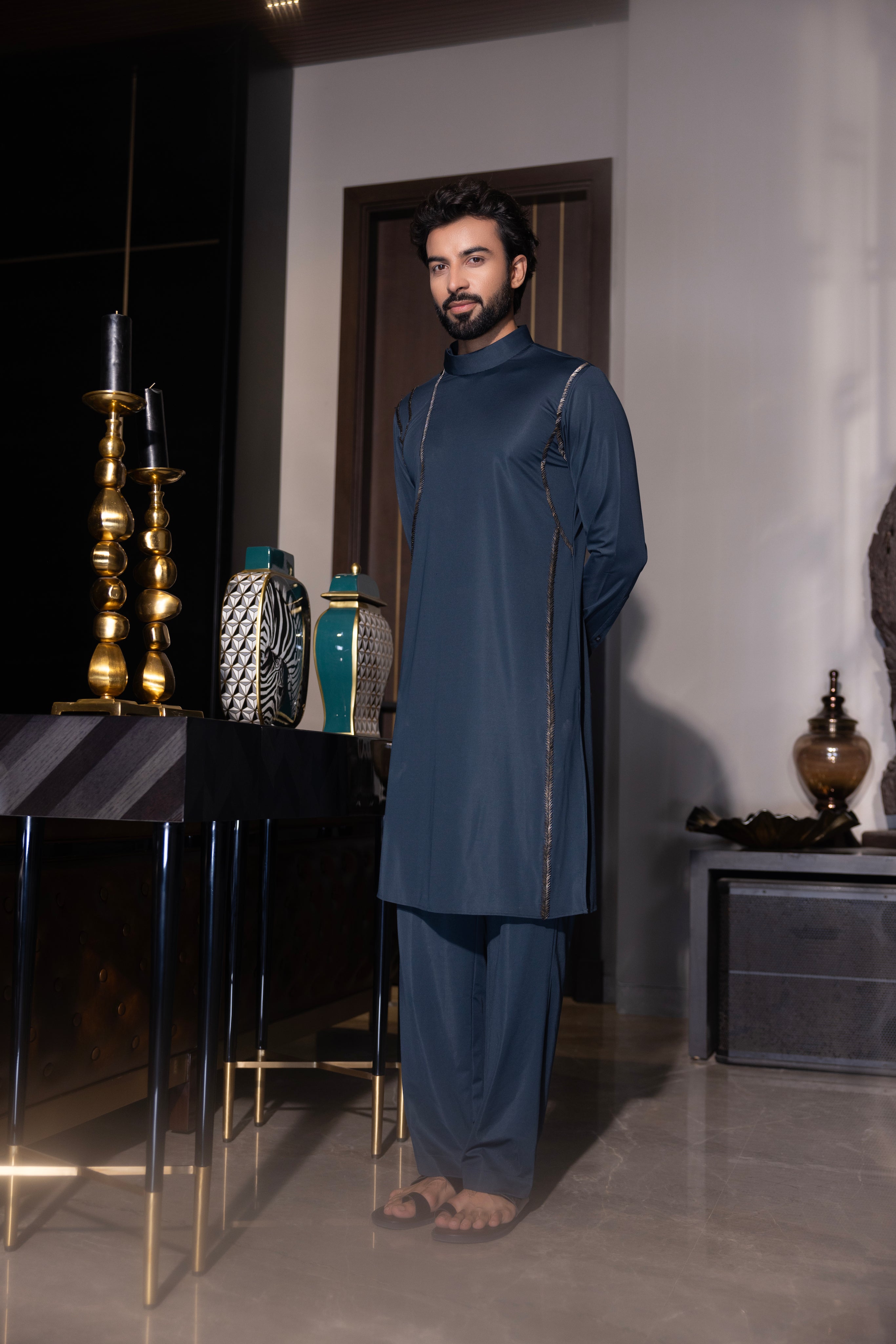 Bottle green kurta with hand-embroidery detailing paired with a matching aligadhi set.