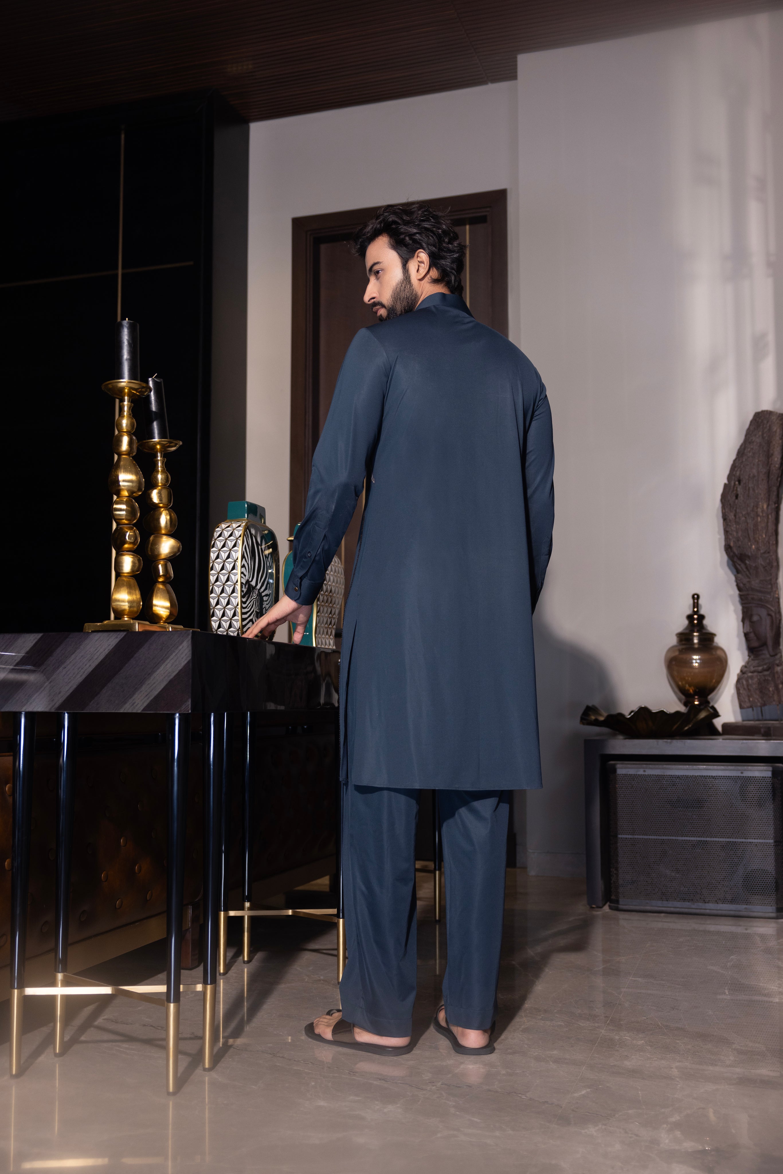 Bottle green kurta with hand-embroidery detailing paired with a matching aligadhi set.
