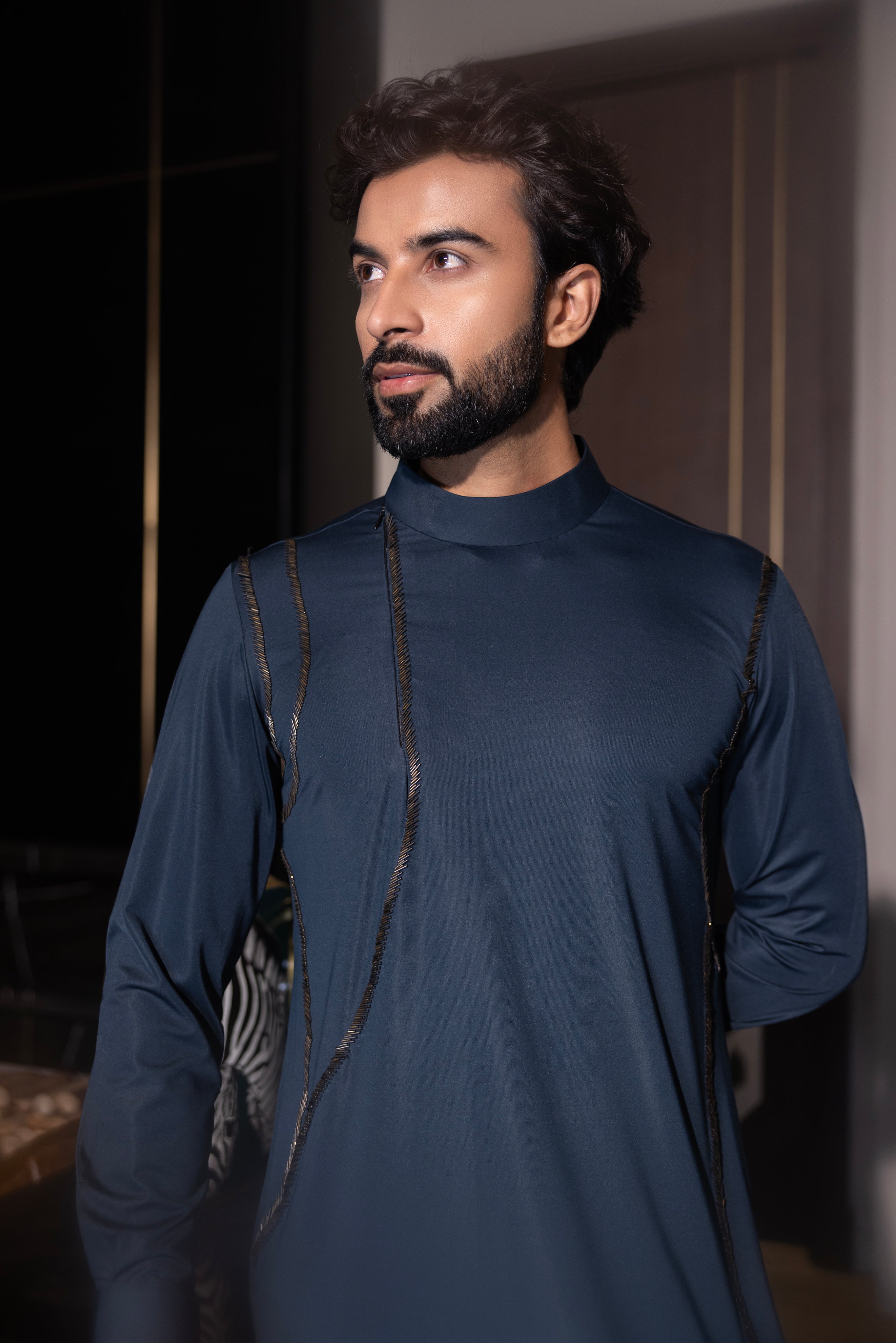 Bottle green kurta with hand-embroidery detailing paired with a matching aligadhi set.