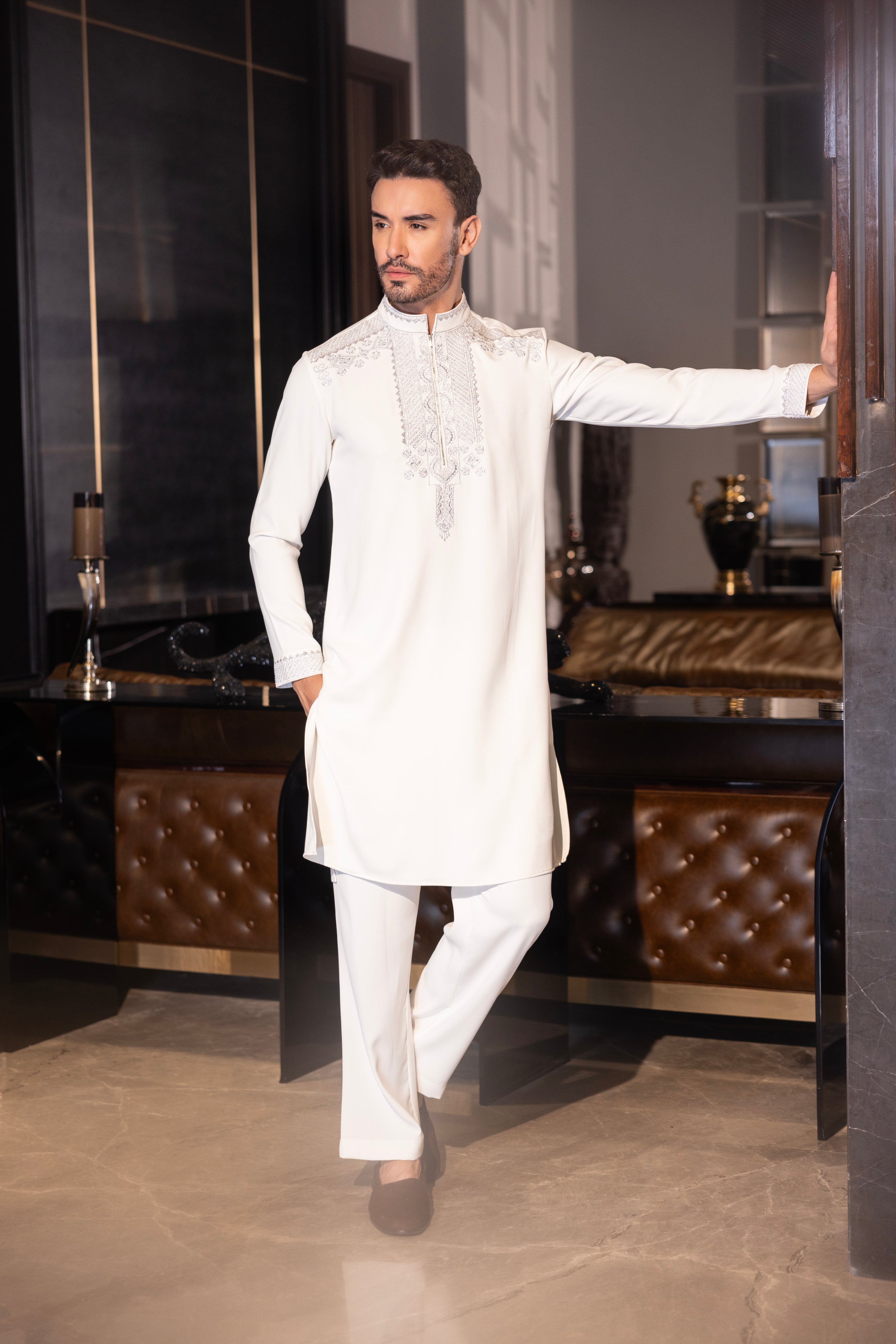 Ivory kurta with hand-embroidery detailing paired with a matching aligadhi set.