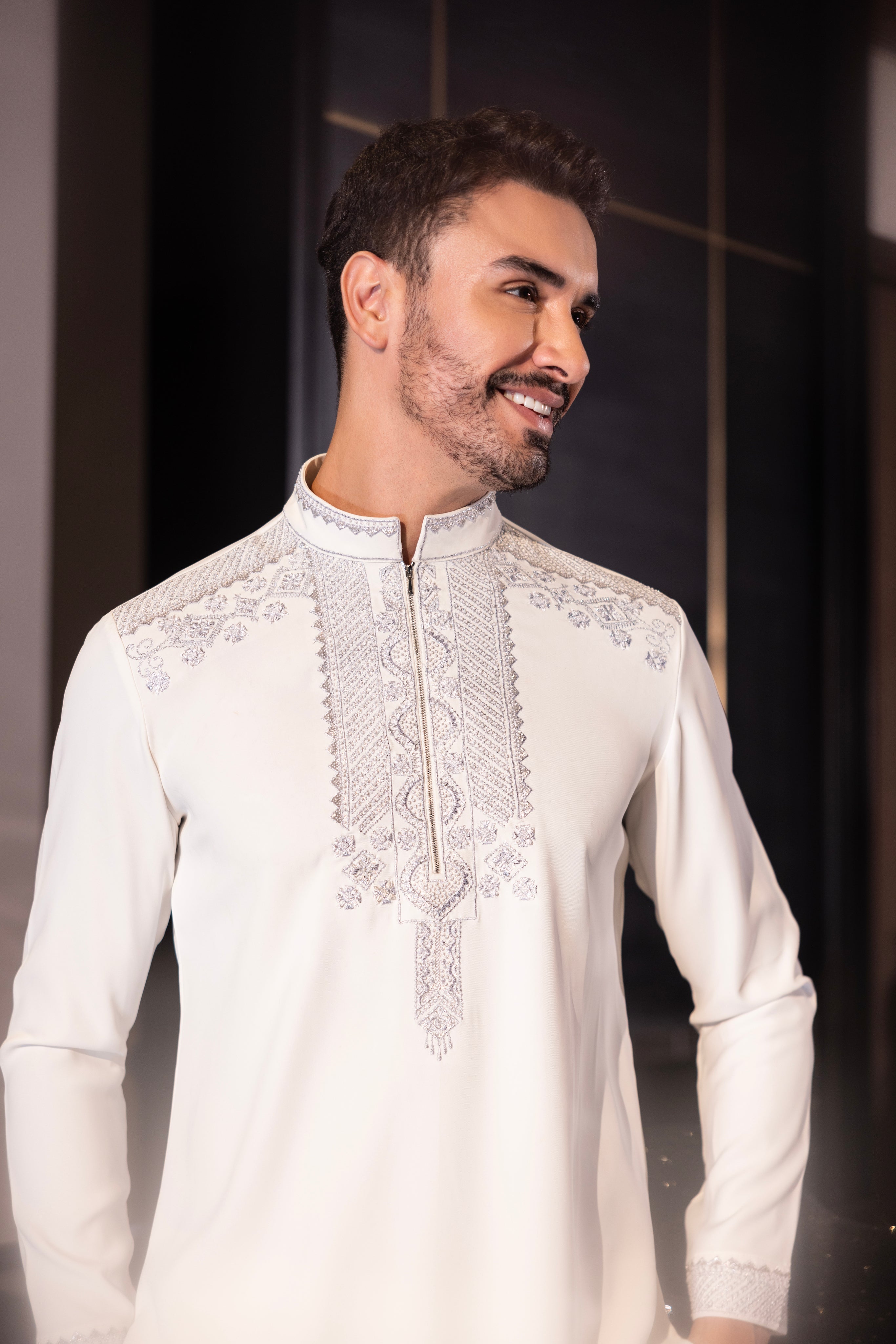 Ivory kurta with hand-embroidery detailing paired with a matching aligadhi set.