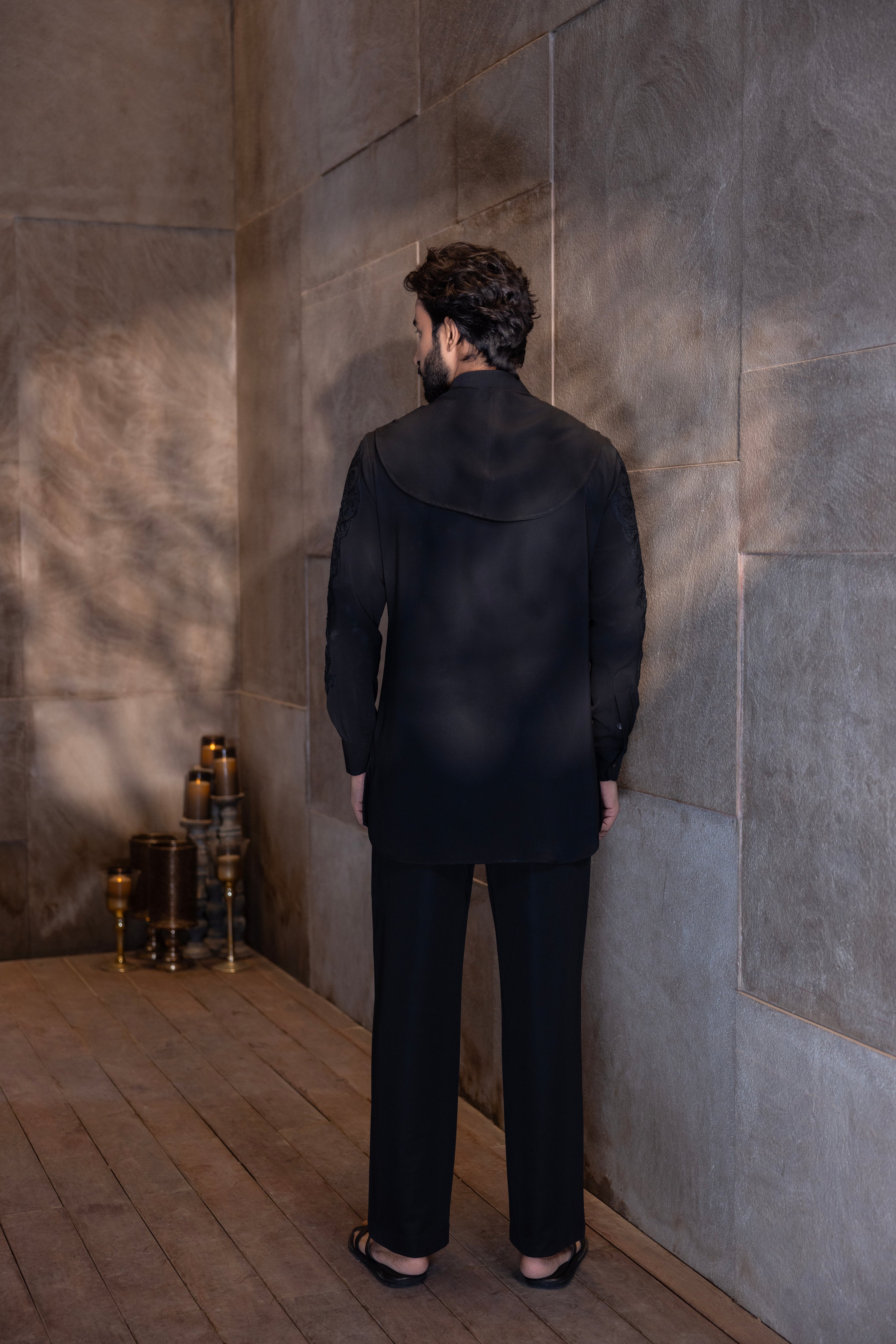Black hand-embroidered kurta with cowl detailing paired with a matching aligadhi set.