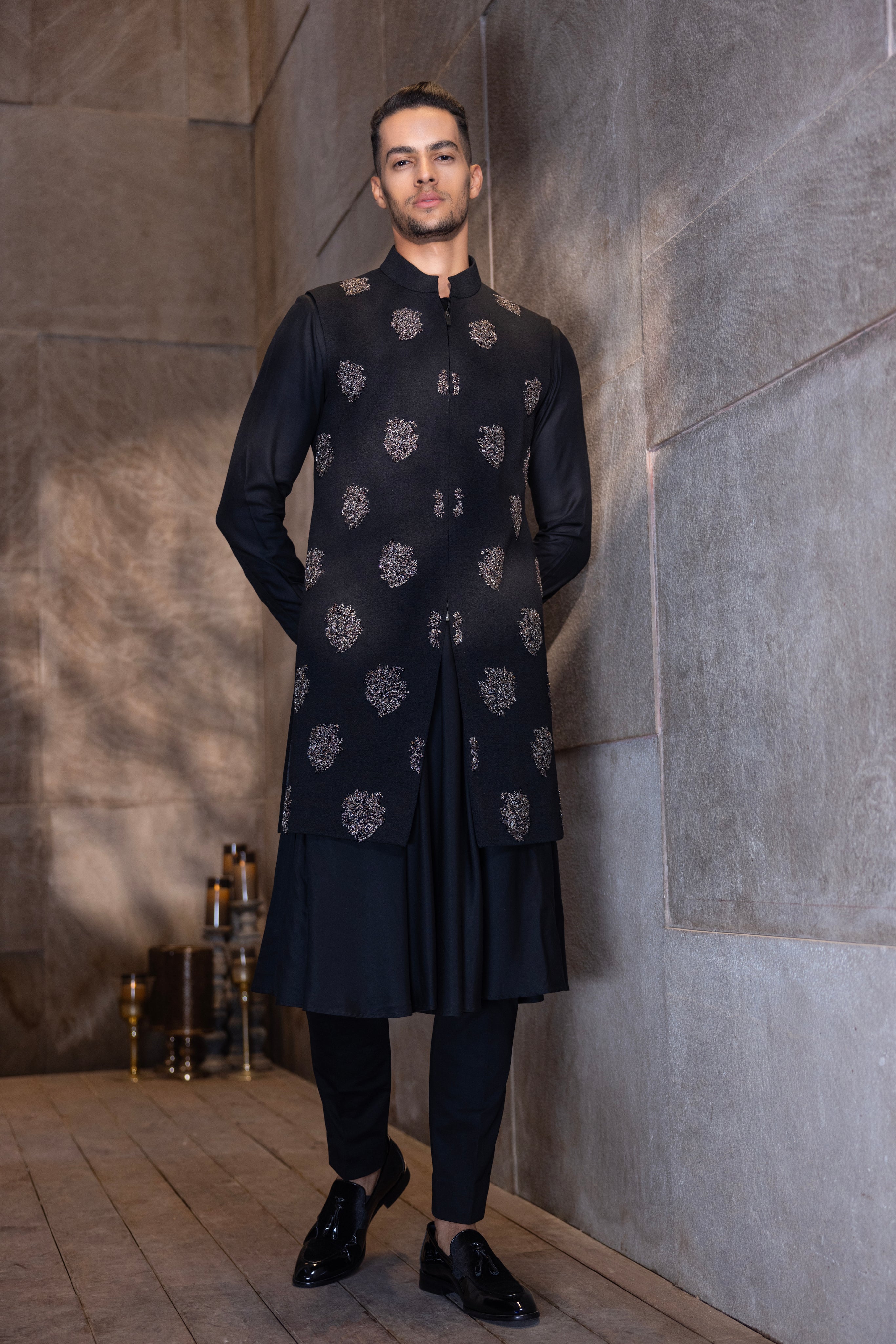 Black long hand-embroidered texturex knit waistcoat paired with a kali kurta and aligadhi set.