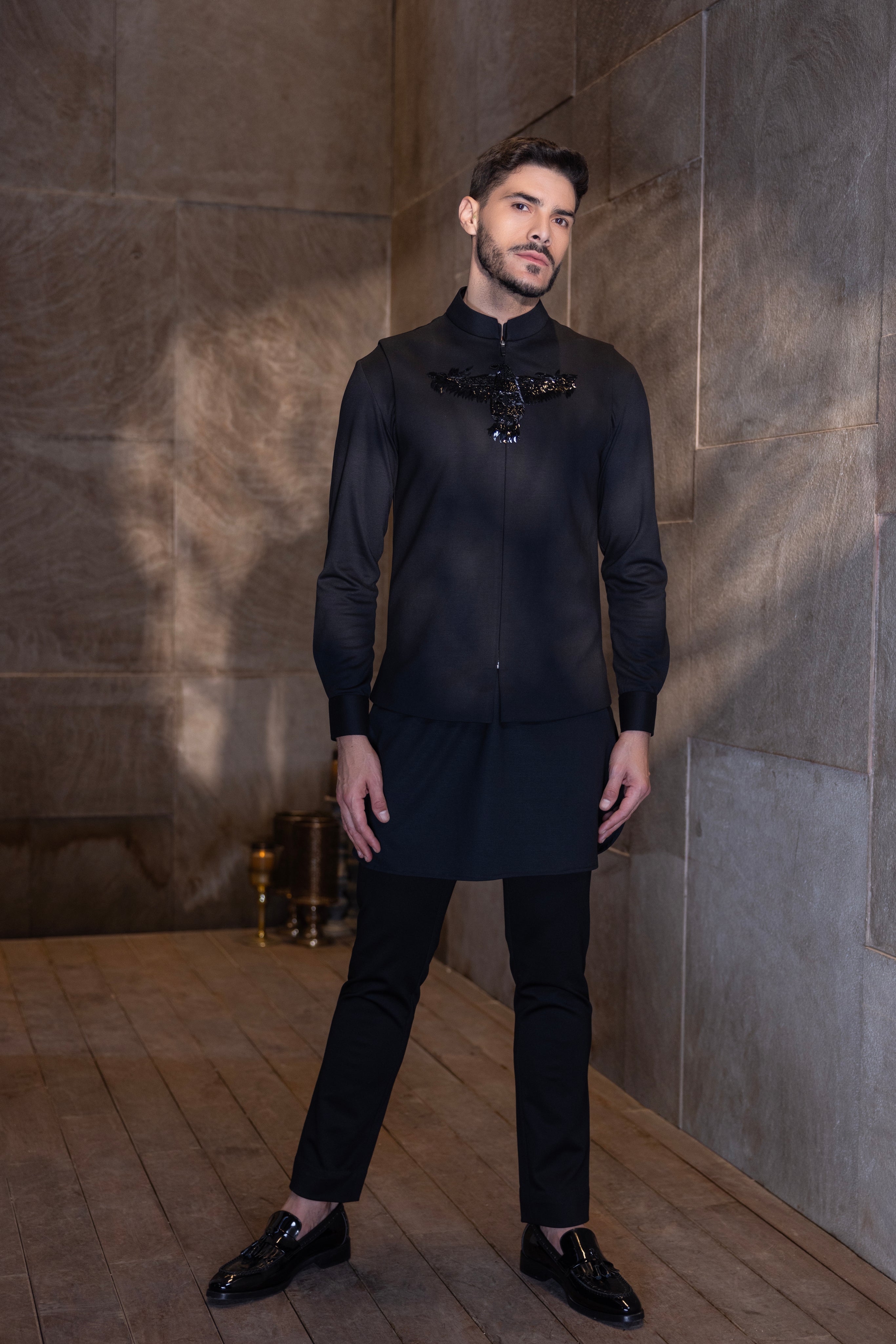 Black waistcoat with a hand-embroidered Bird motif paired with a matching kurta and aligadhi set.