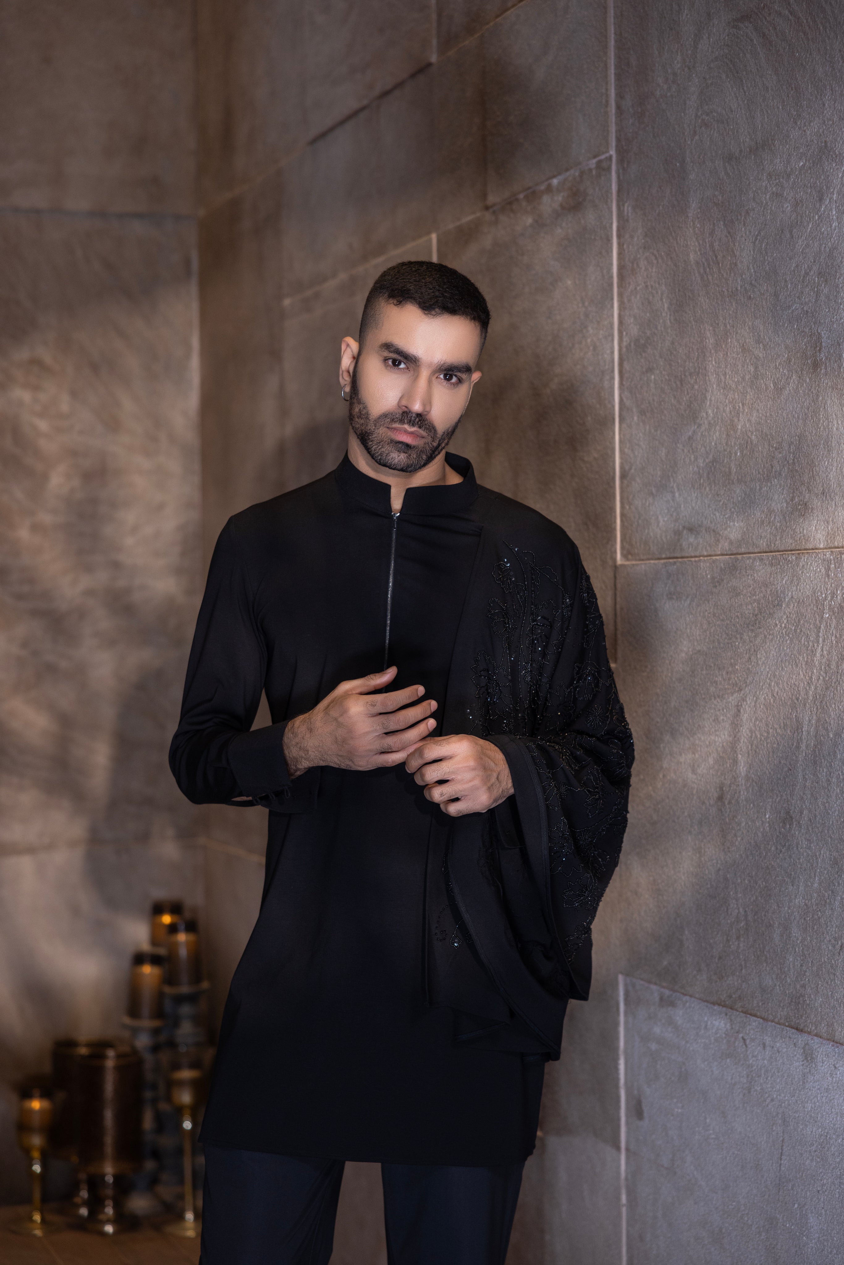 Black hand-embroidered kurta with draping details paired with a matching aligadhi set.