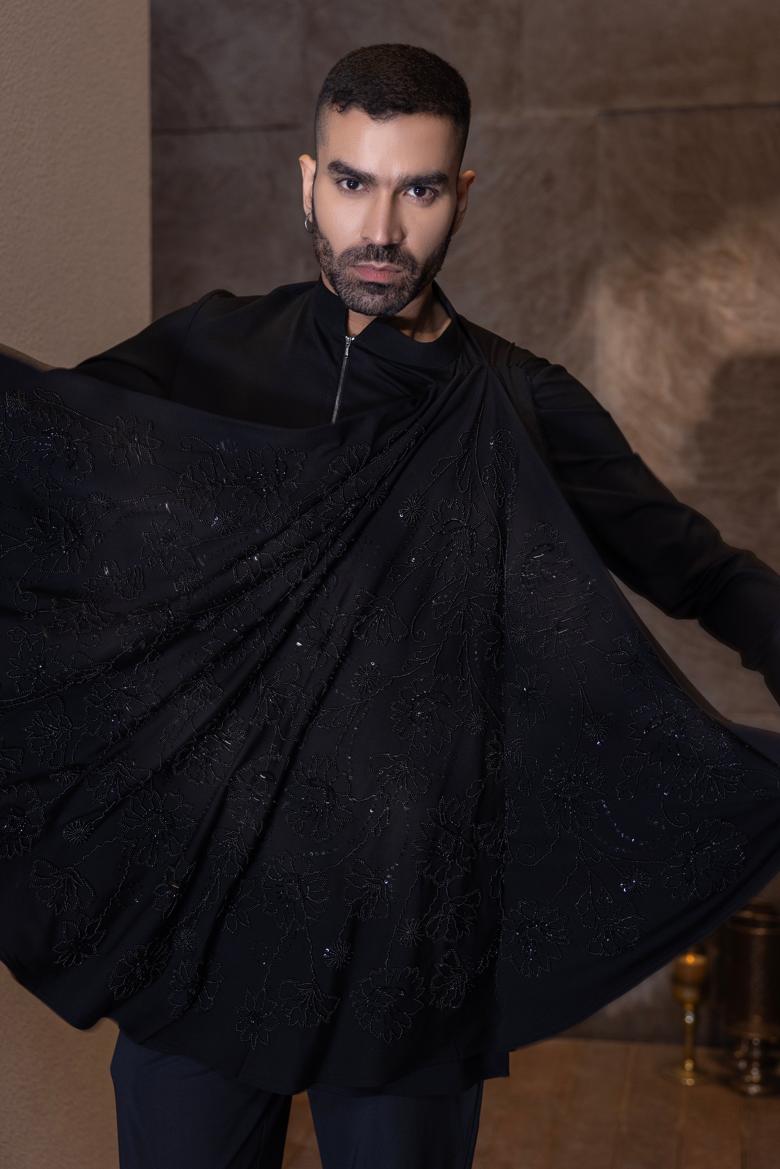 Black hand-embroidered kurta with draping details paired with a matching aligadhi set.