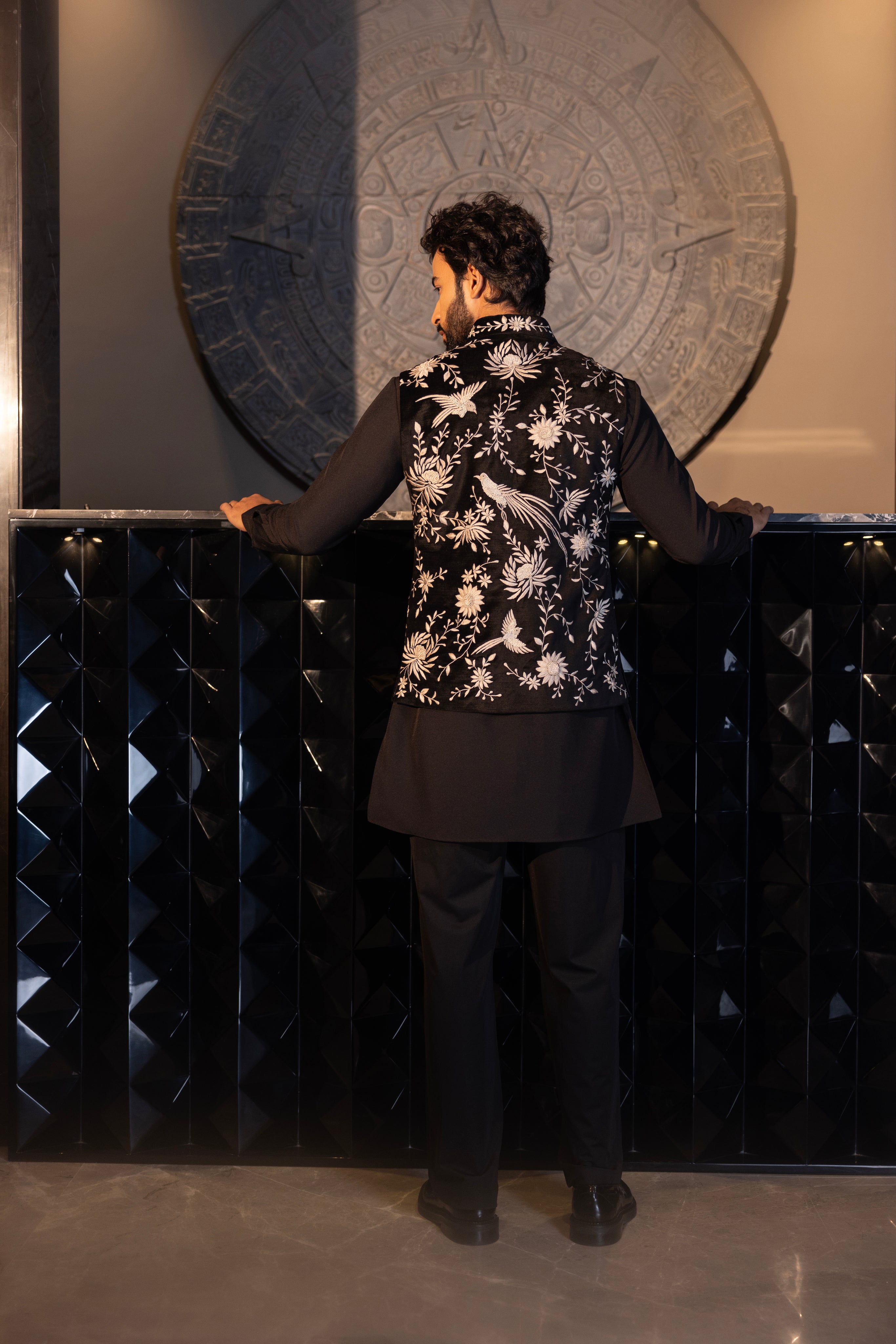 Black waistcoat with contrast hand-embroidery paired with a matching kurta and aligadhi set.