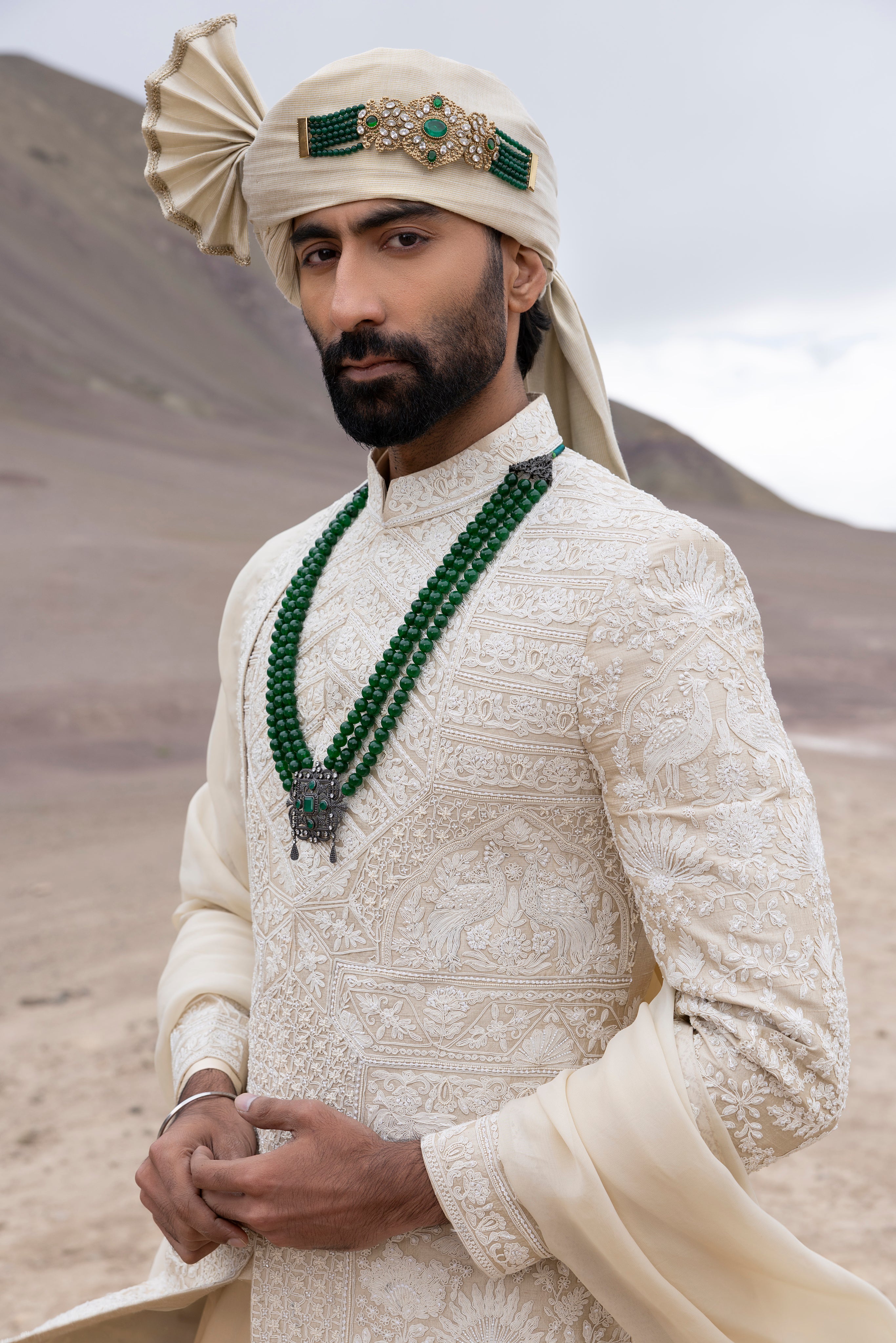 Beige raw silk sherwani with intricate hand-embroidery paired with a modal kurta pyjama & an organza stole.