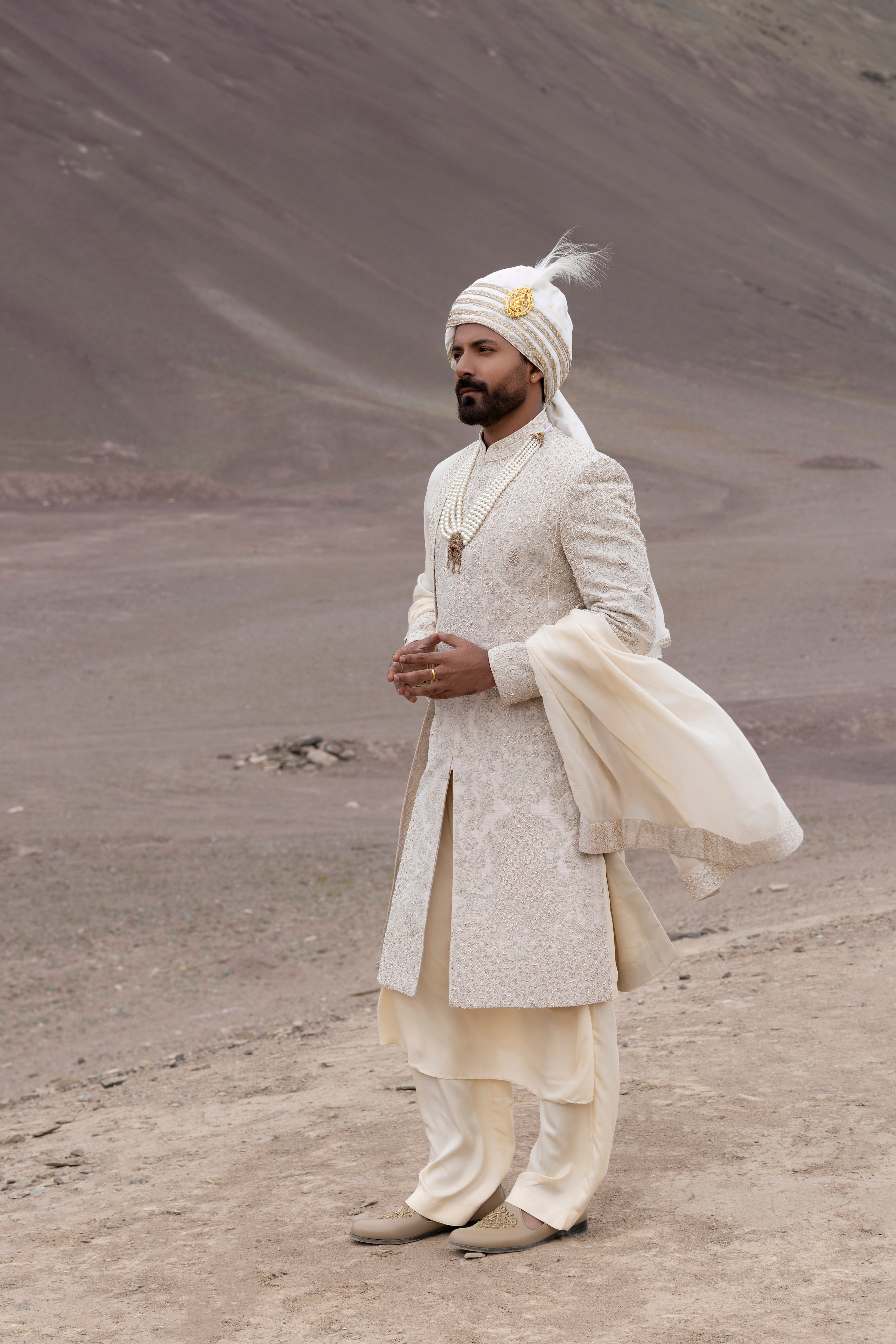 Peach raw silk sherwani with intricate hand-embroidery paired with a modal kurta pyjama & an organza stole.