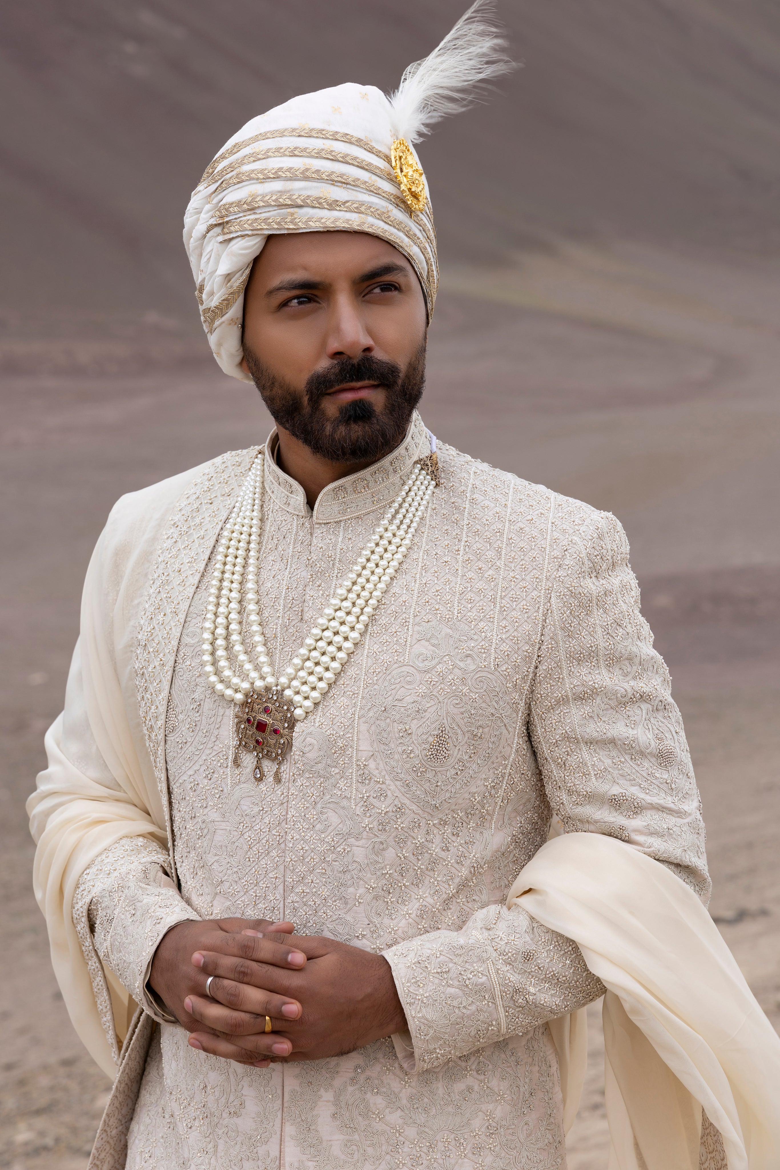 Peach raw silk sherwani with intricate hand-embroidery paired with a modal kurta pyjama & an organza stole.