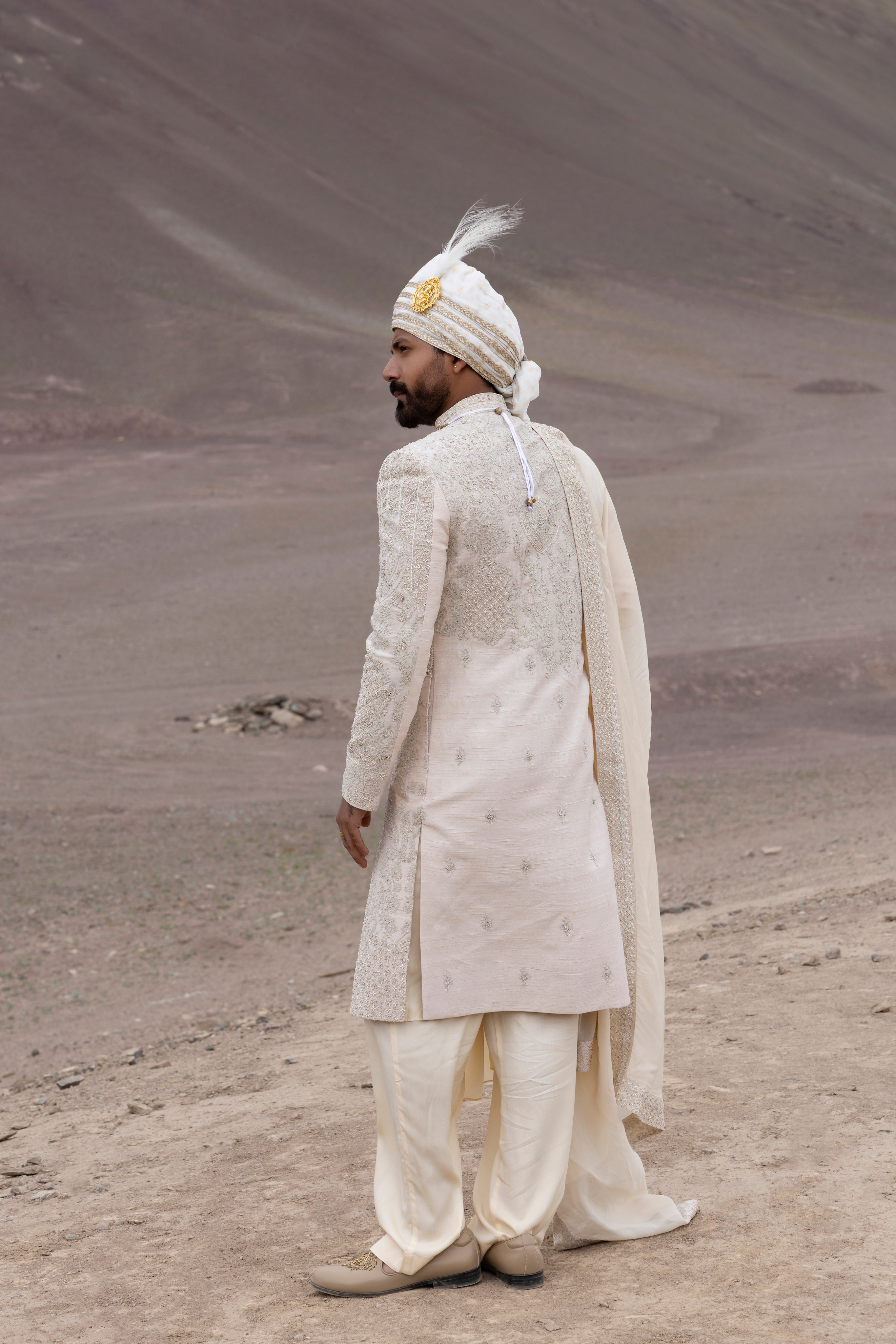 Peach raw silk sherwani with intricate hand-embroidery paired with a modal kurta pyjama & an organza stole.