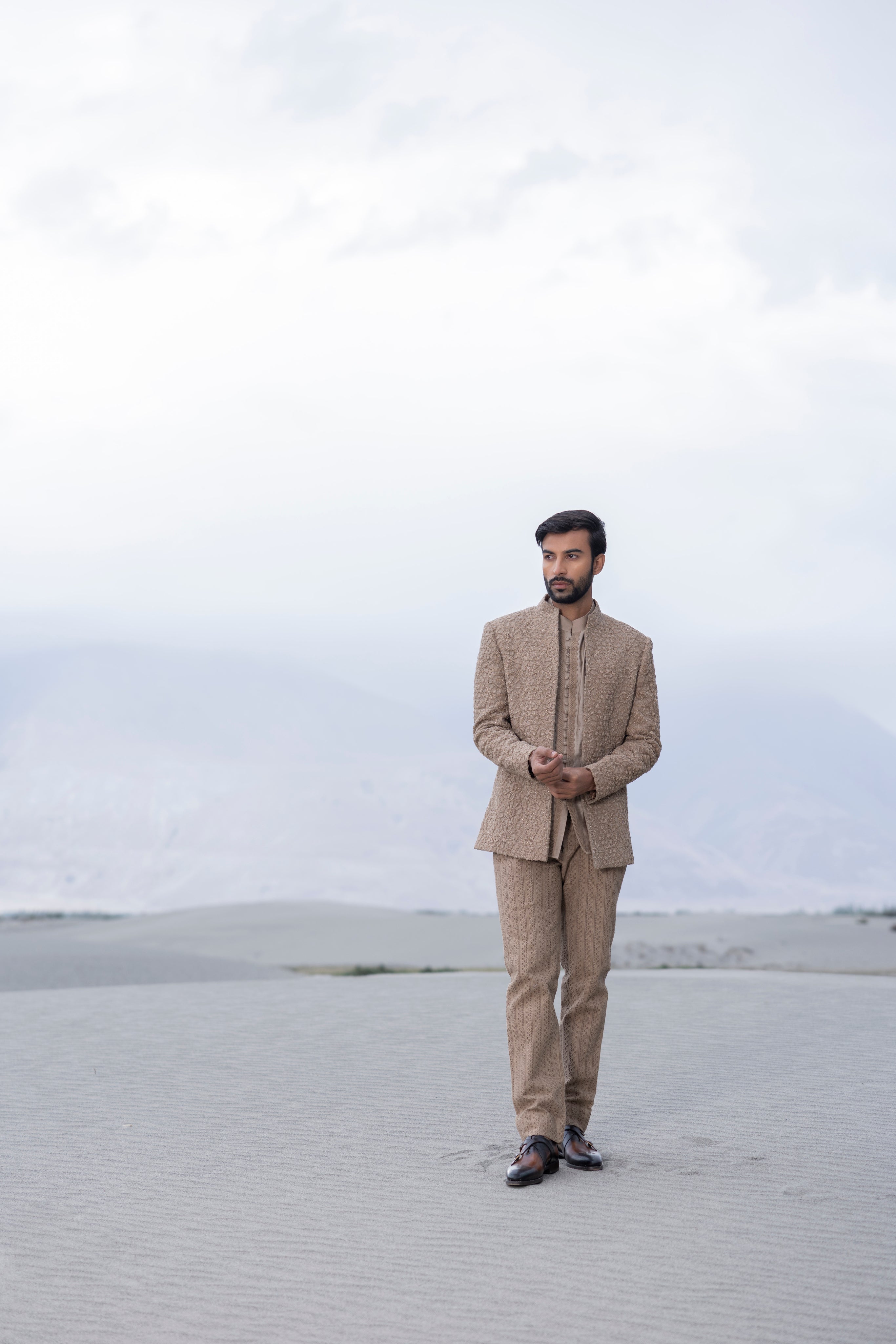 khakhi crochet hand-embroidered open indowestern jacket paired with a short kurta and pants with crochet detailing.