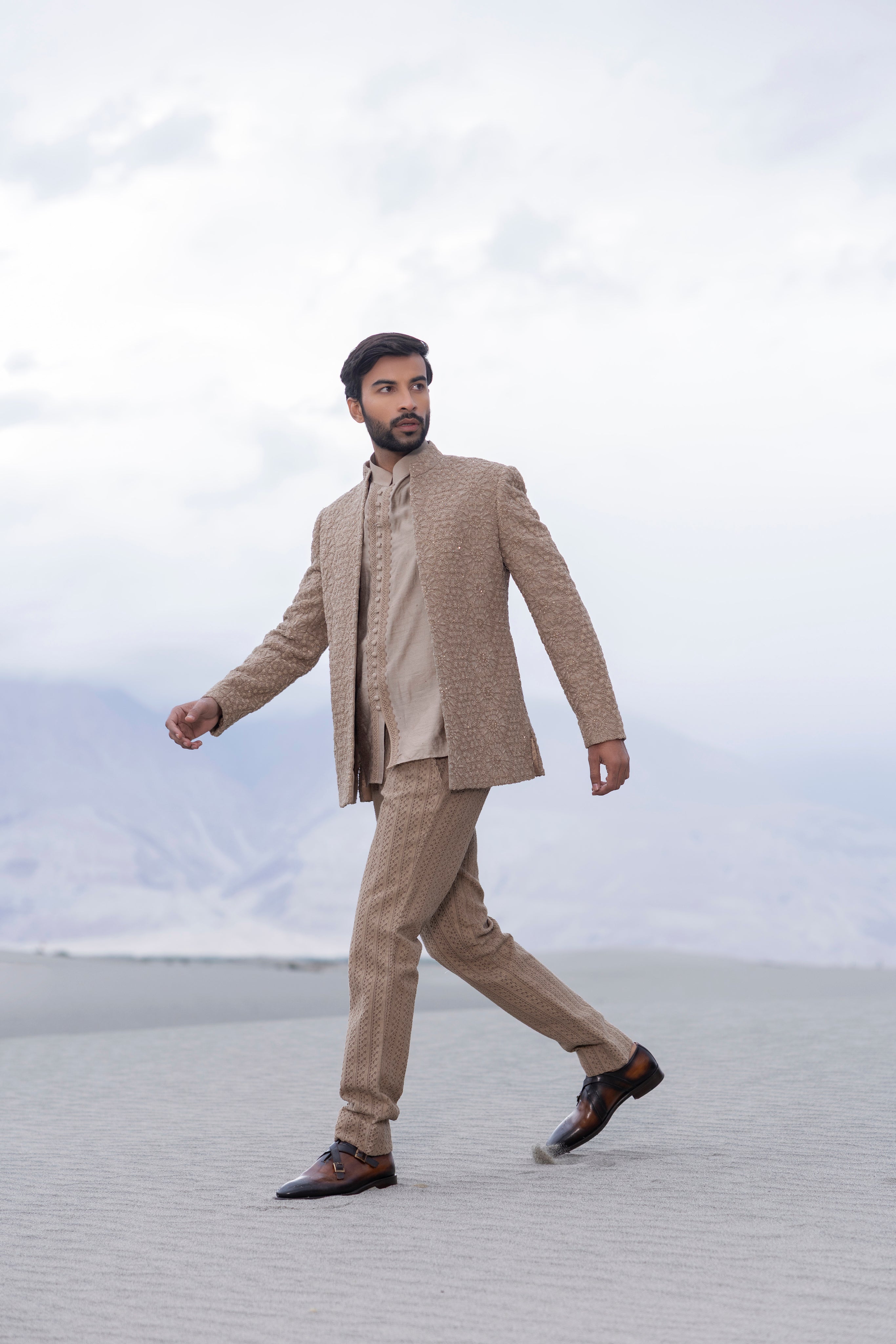khakhi crochet hand-embroidered open indowestern jacket paired with a short kurta and pants with crochet detailing.