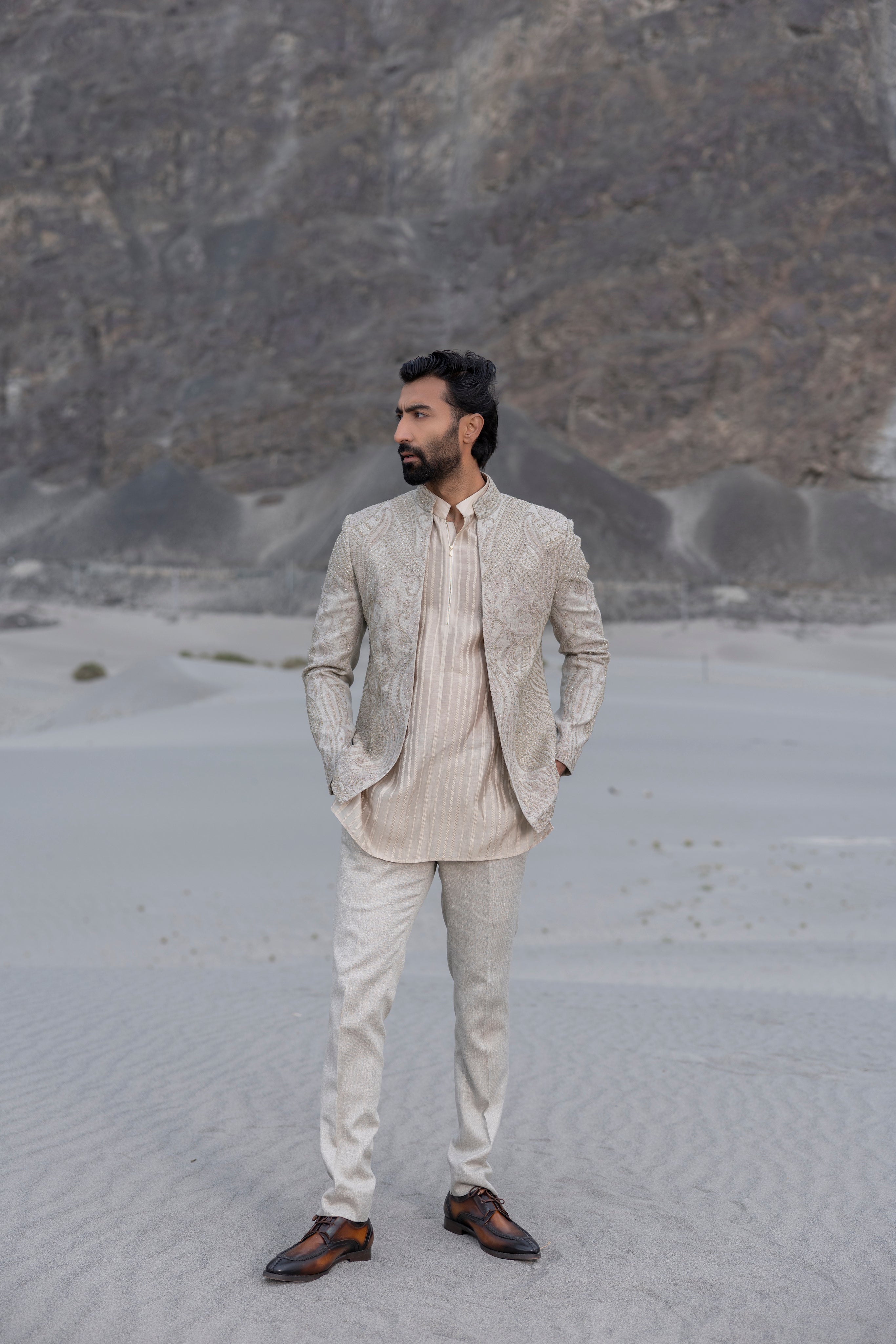 Beige textured knit, front open short indowestern jacket with monotone hand-embroidery paired with an embroidered silk kurta and a textured knit pant.
