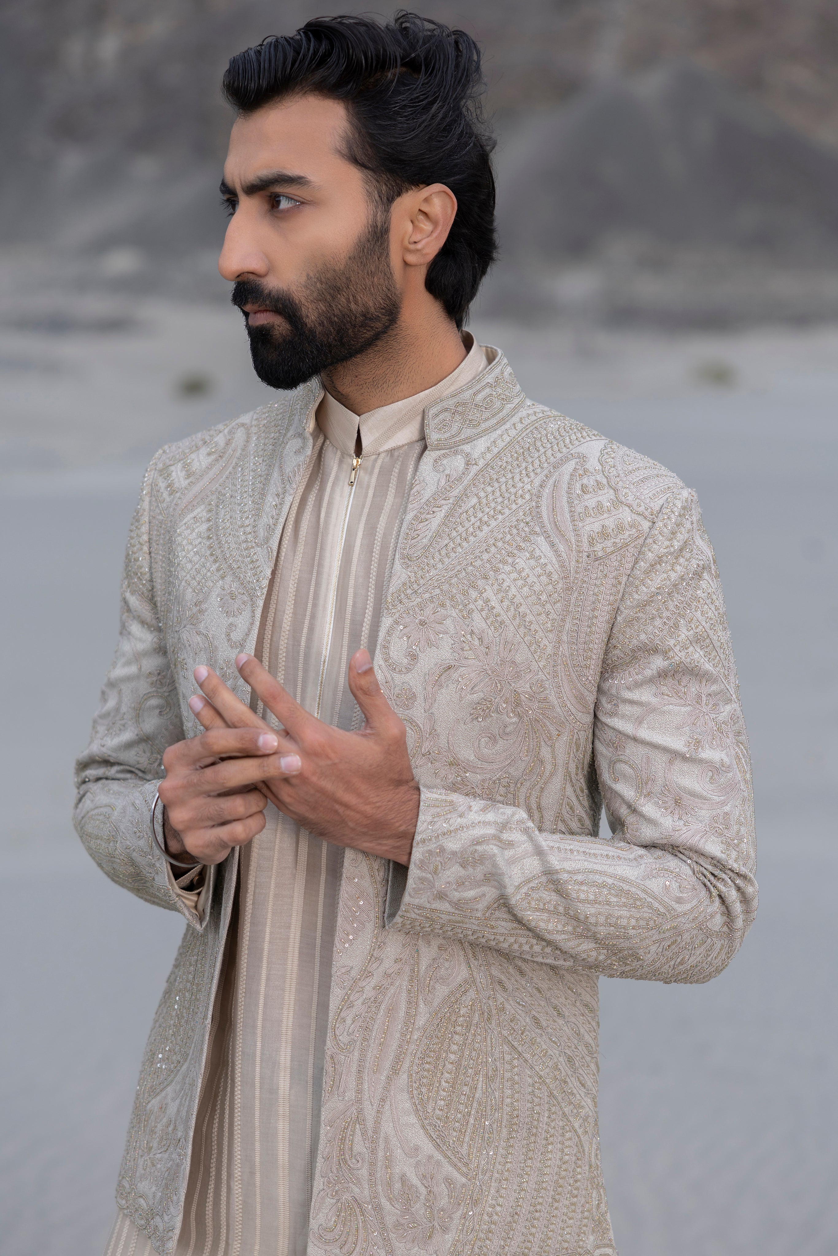 Beige textured knit, front open short indowestern jacket with monotone hand-embroidery paired with an embroidered silk kurta and a textured knit pant.