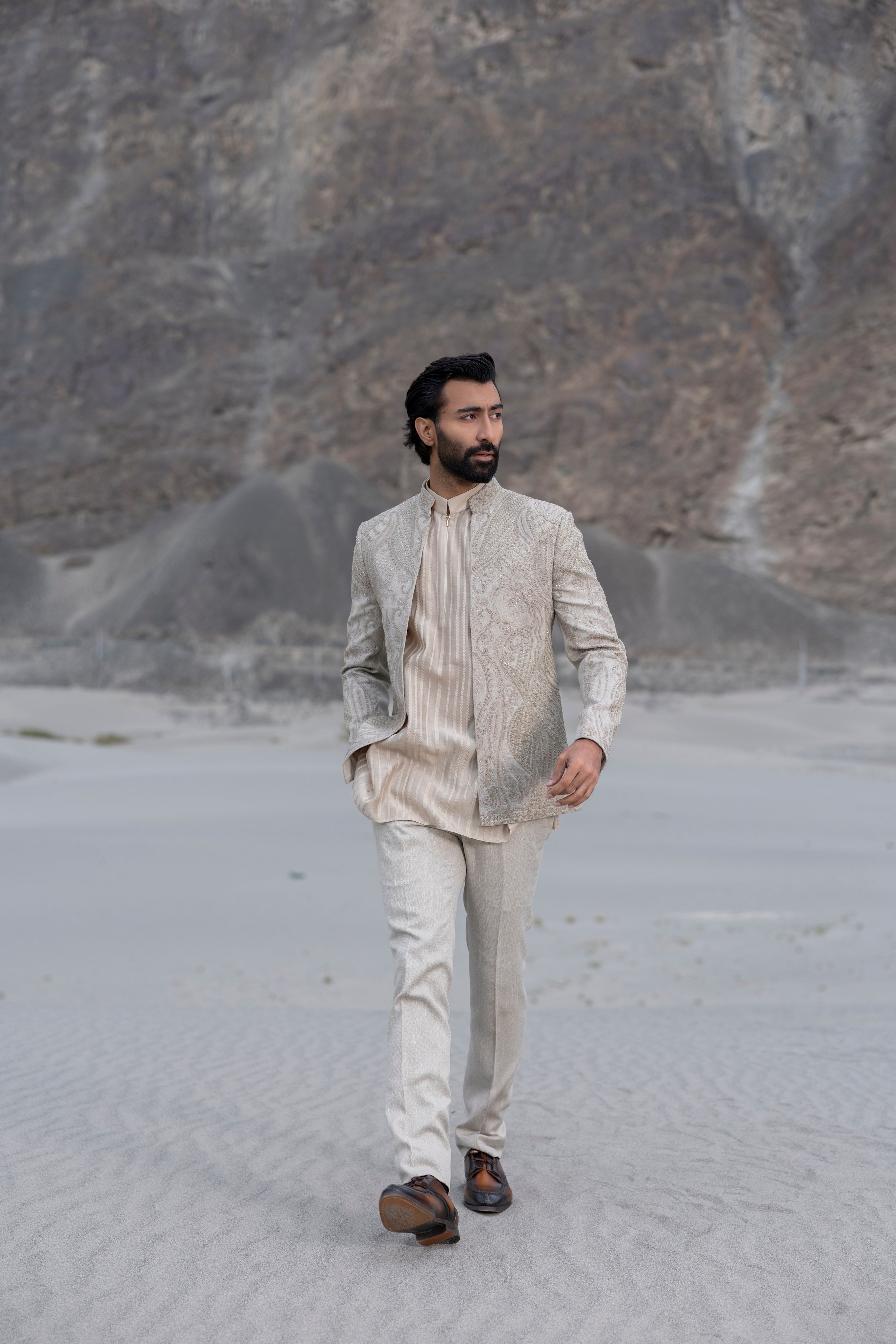 Beige textured knit, front open short indowestern jacket with monotone hand-embroidery paired with an embroidered silk kurta and a textured knit pant.