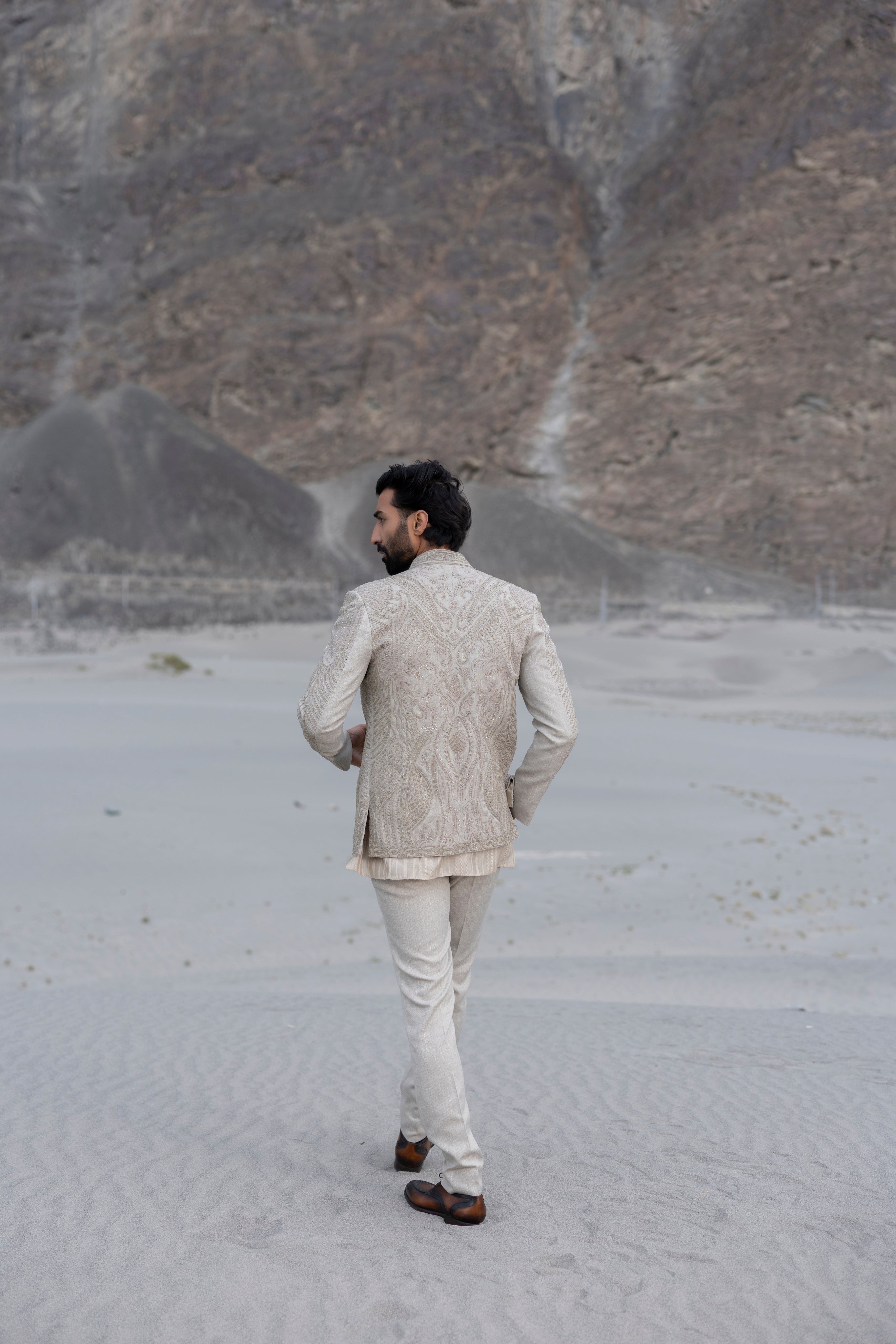 Beige textured knit, front open short indowestern jacket with monotone hand-embroidery paired with an embroidered silk kurta and a textured knit pant.