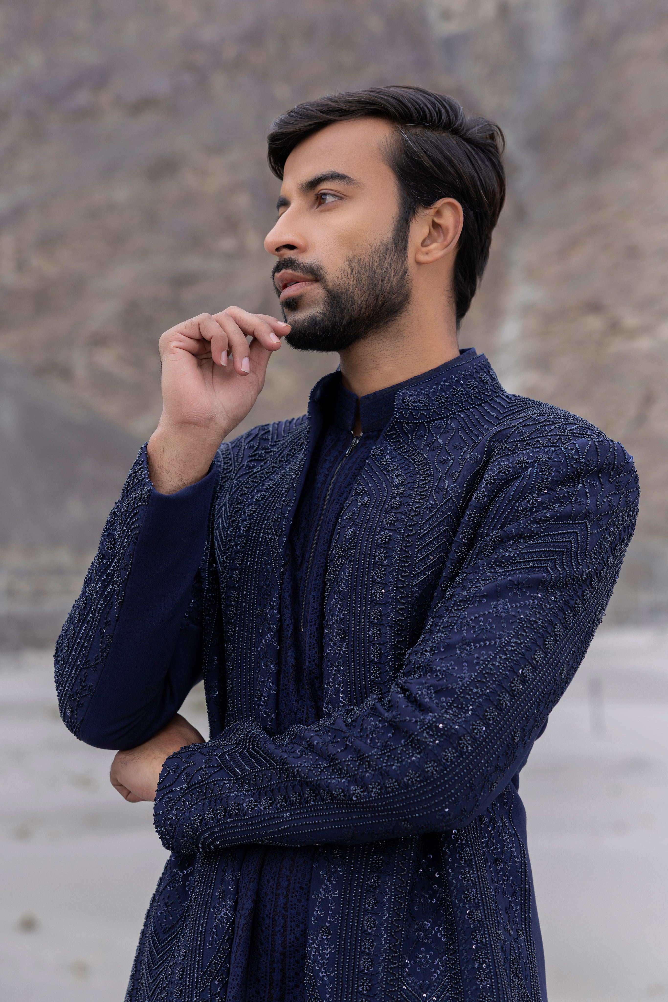 Navy Blue front open short indowestern jacket with monotone hand-embroidery paired with a crochet kurtawith zipper detailing  and a pant.