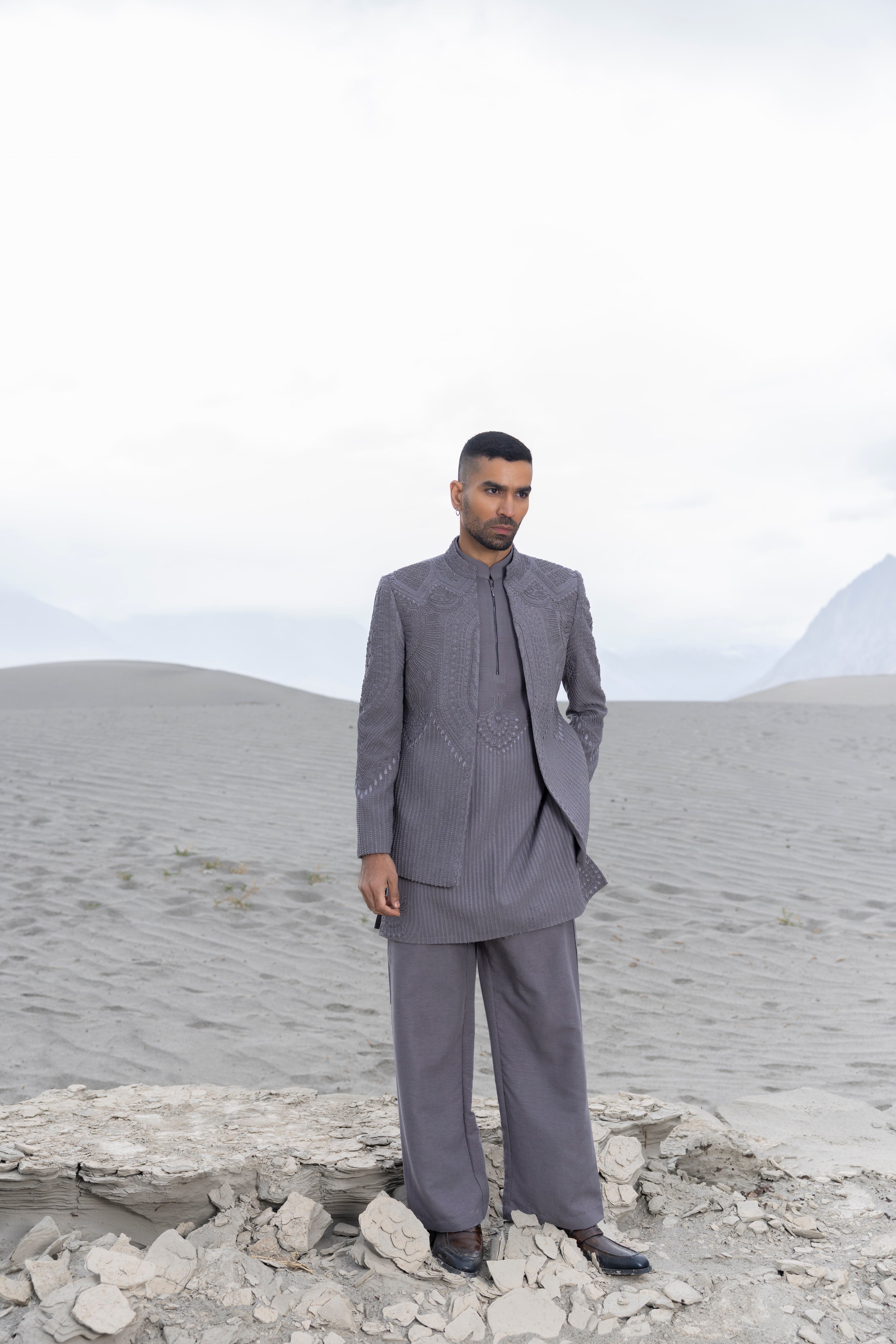 Grey front open hand-embroidered indowestern jacket paired with an hand-embroidered  kurta and pants.