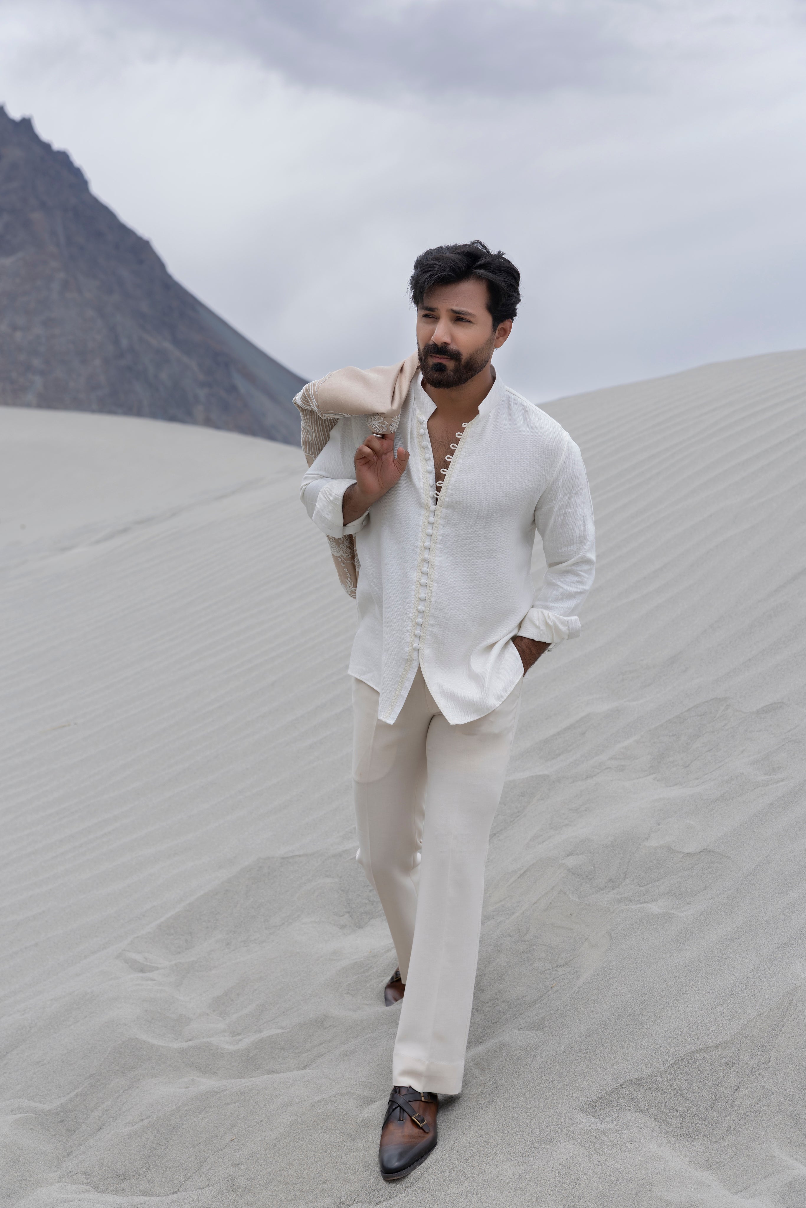 Beige hand-embroidered open short indowestern jacket paired with a short loop button kurta and pants.