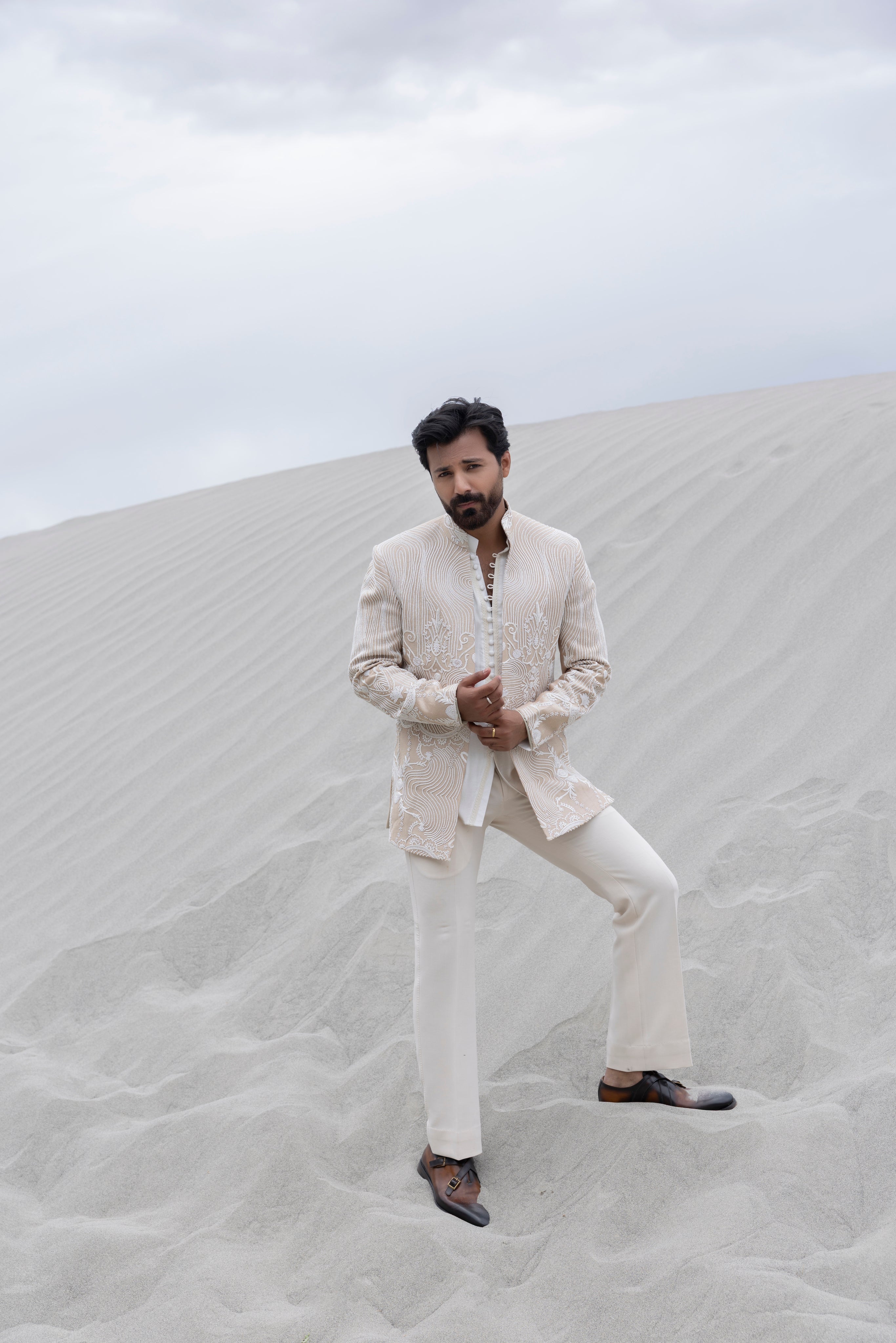 Beige hand-embroidered open short indowestern jacket paired with a short loop button kurta and pants.