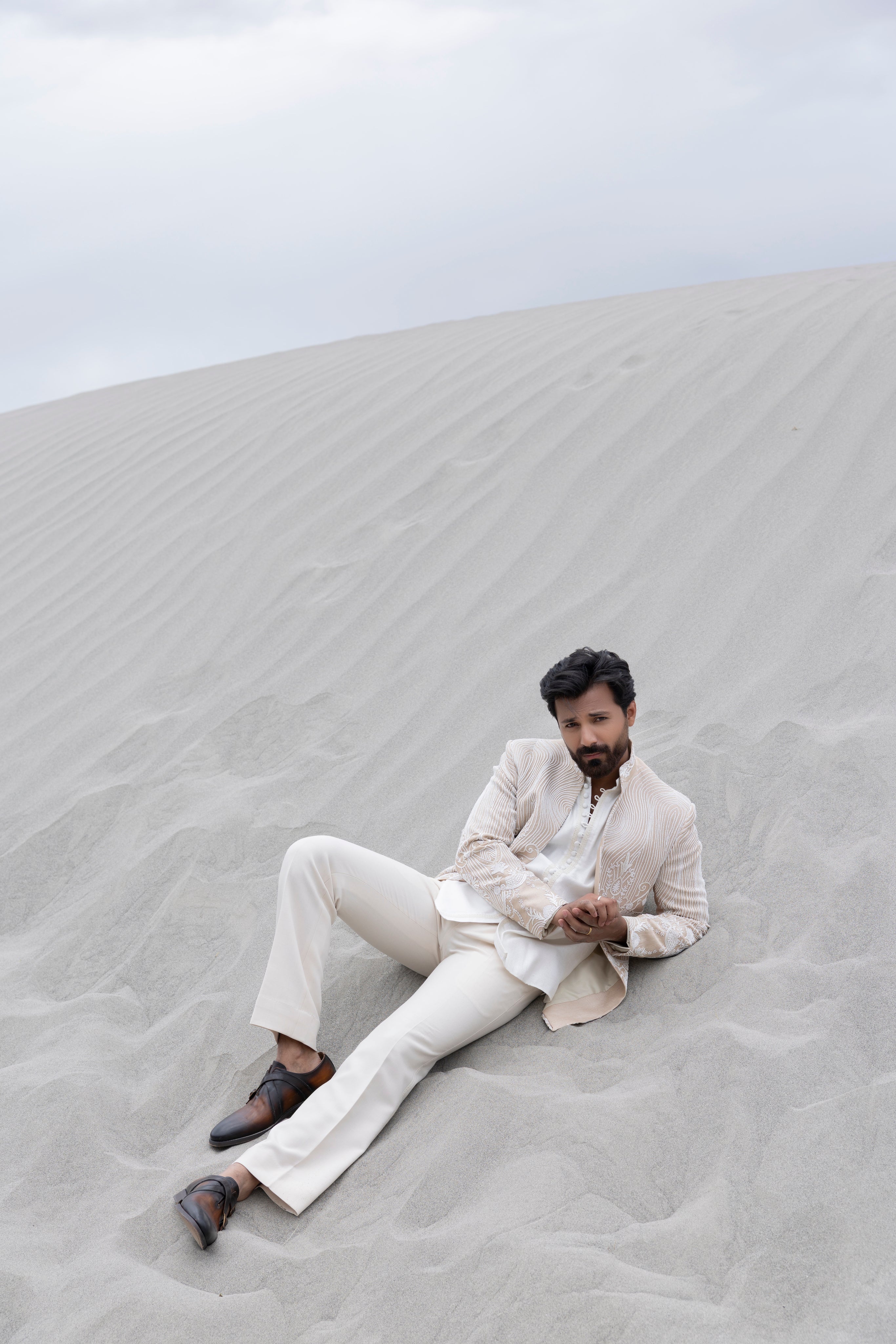 Beige hand-embroidered open short indowestern jacket paired with a short loop button kurta and pants.