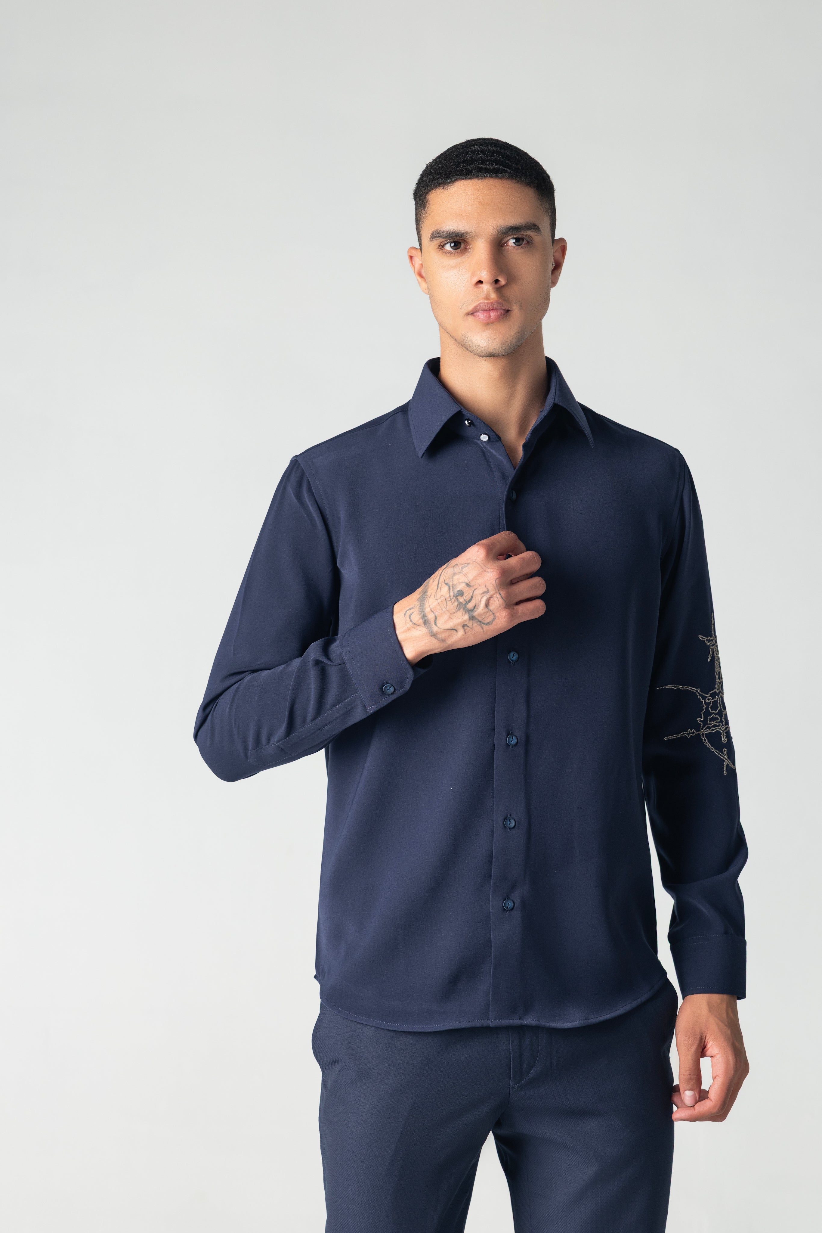 Navy blue shirt with hand-embroidered metallic motif on sleeve