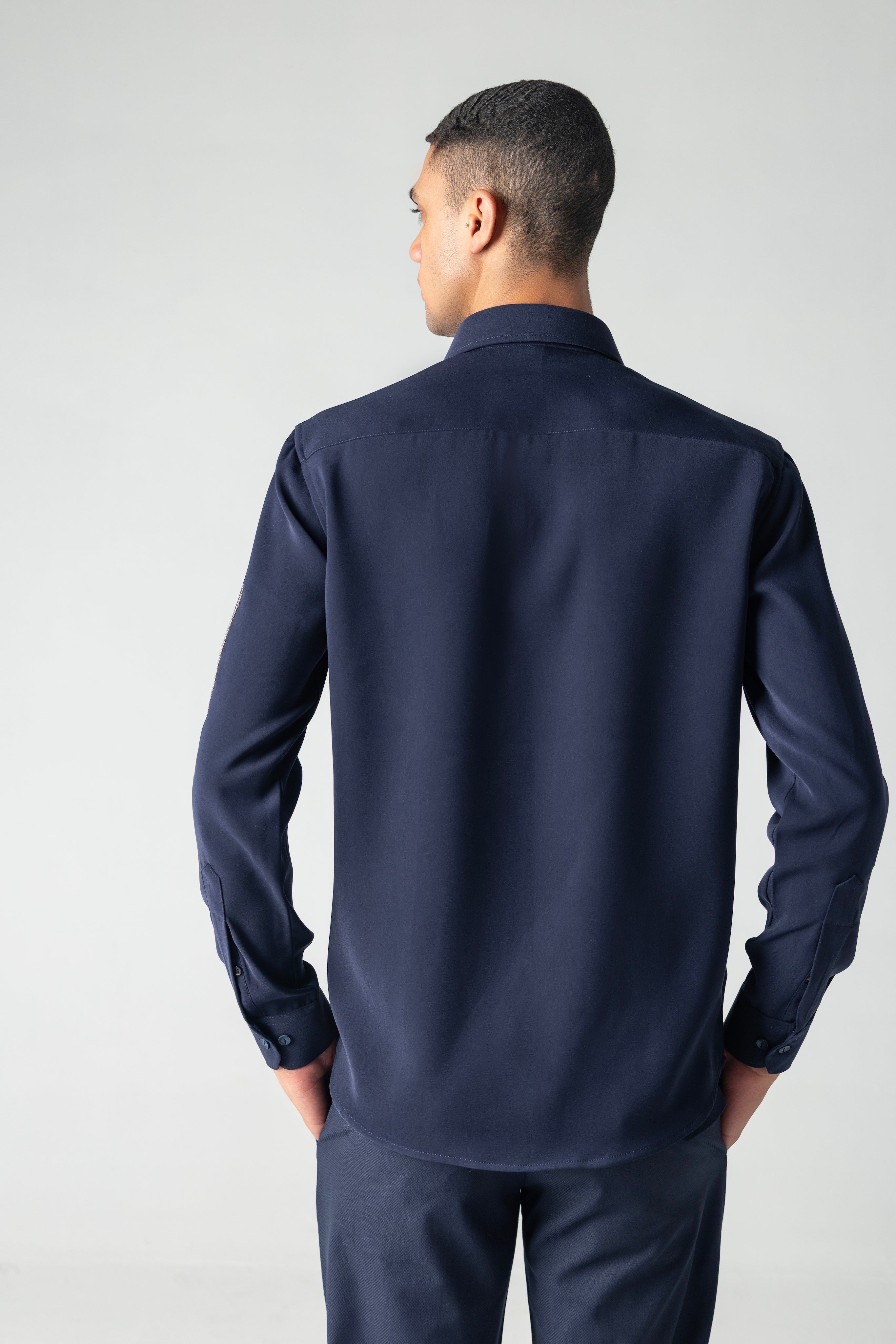 Navy blue shirt with hand-embroidered metallic motif on sleeve