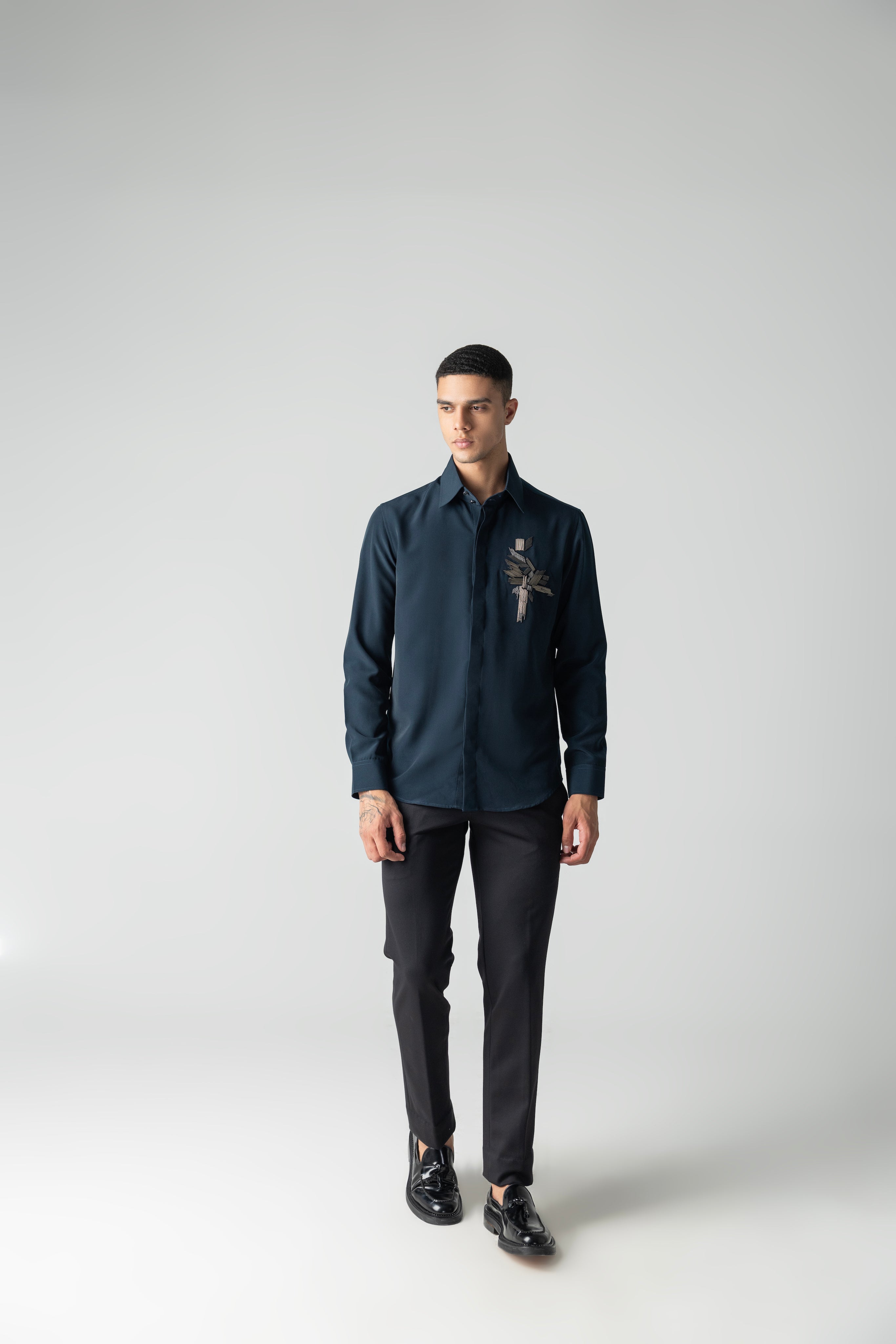 Turquoise shirt with hand-embroidered metal motif