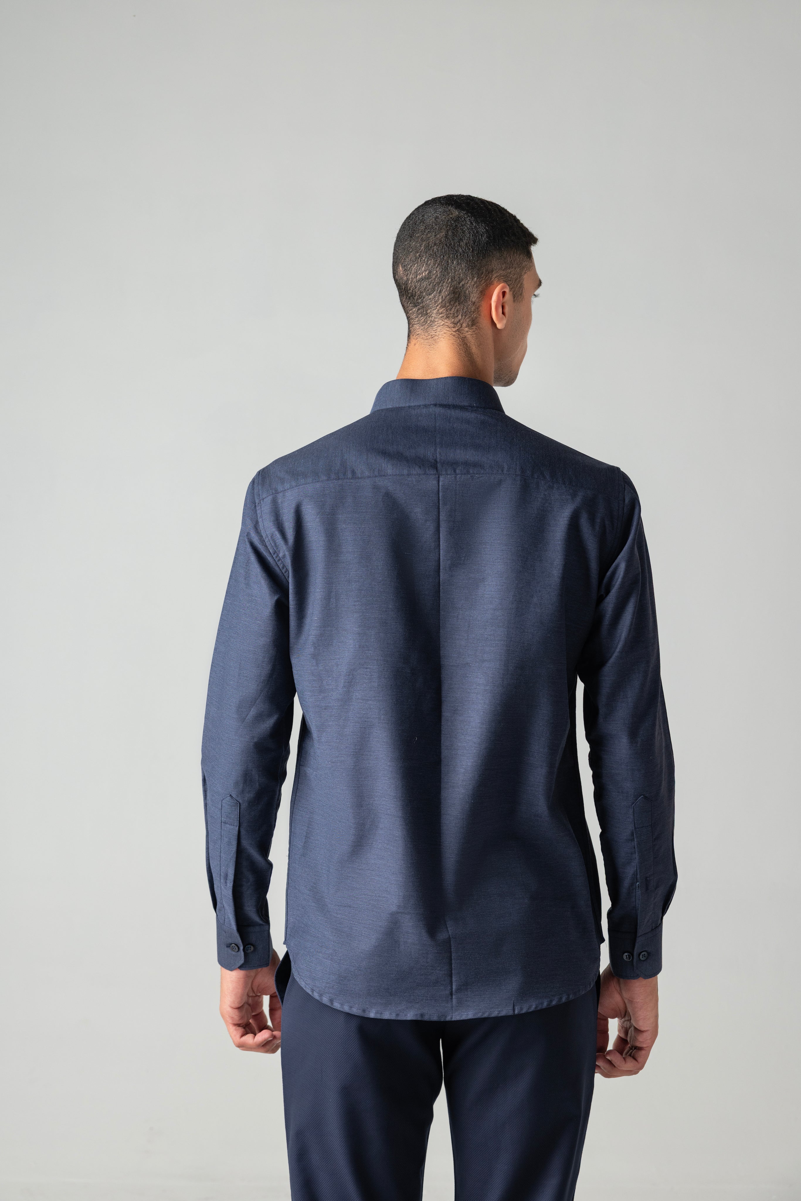 Blue knit shirt with hand-embroidered bird motif on Mandarin collar