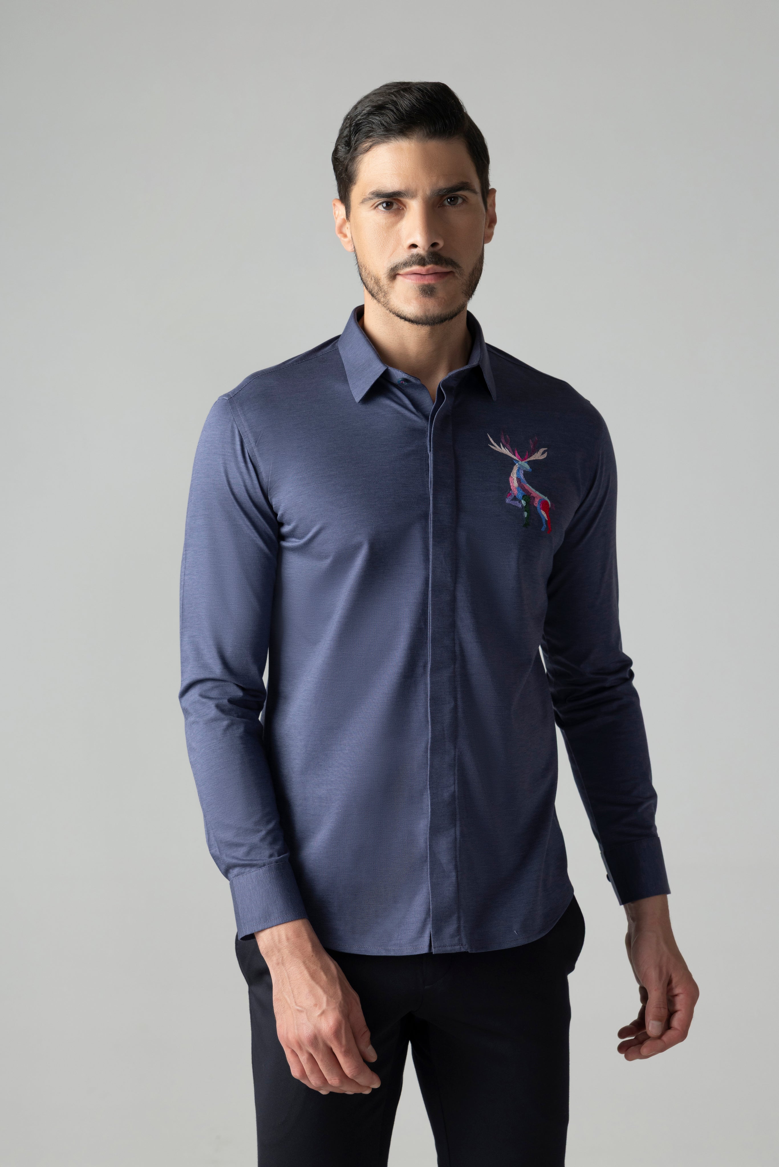 Navy blue knit shirt with embroidered multi-coloured Reindeer motif