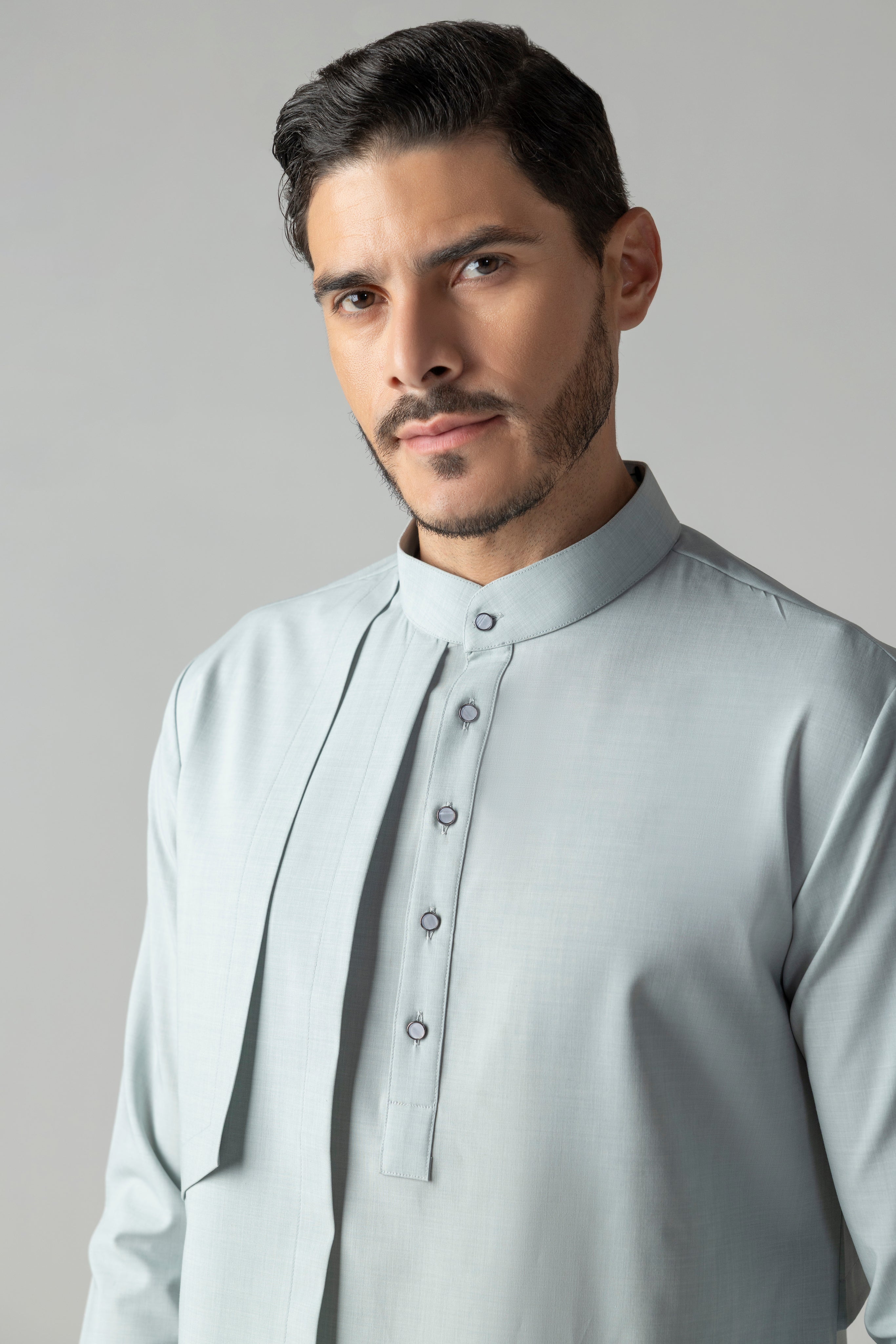Light teal shirt with asymmetrical cuts & drapes