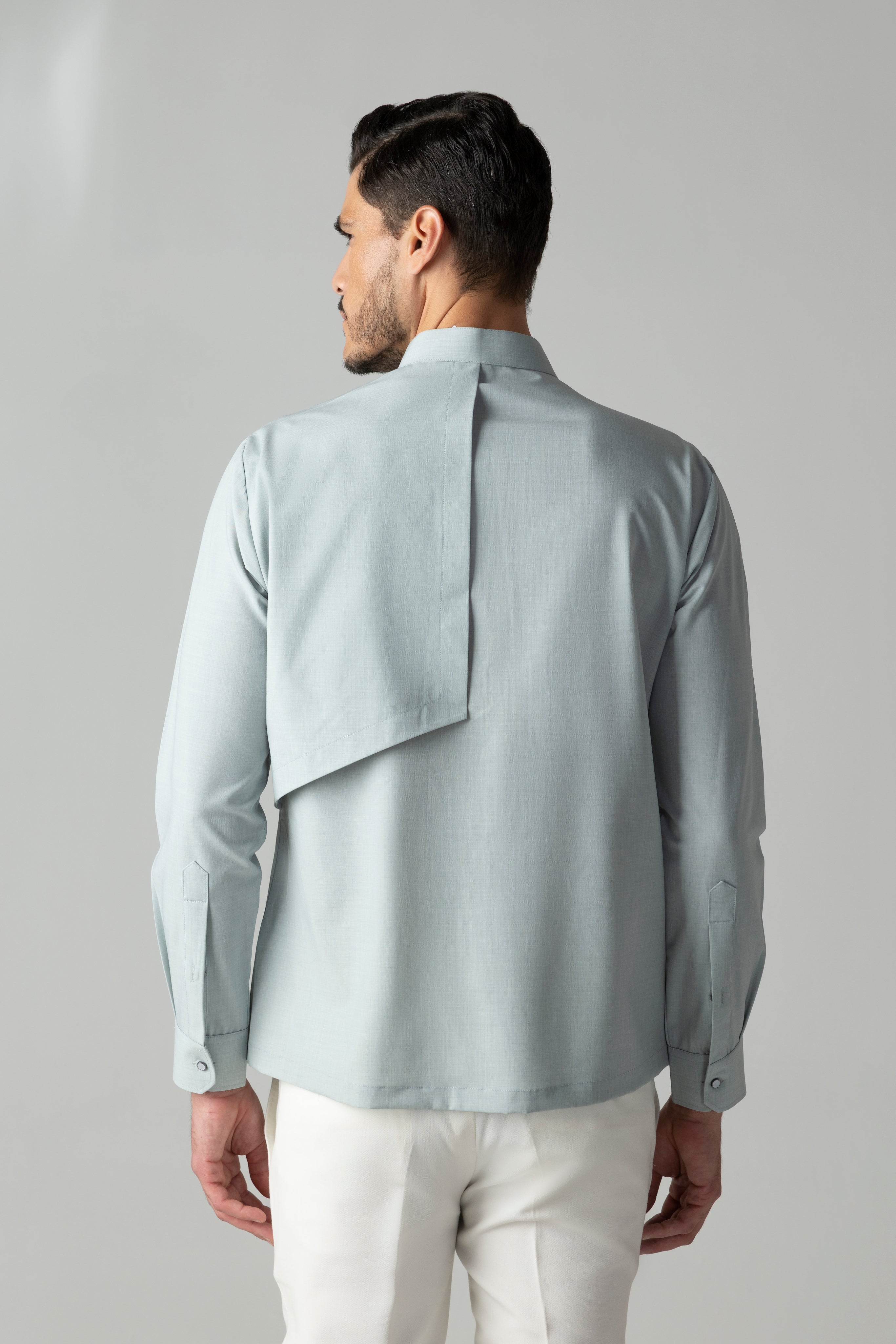 Light teal shirt with asymmetrical cuts & drapes