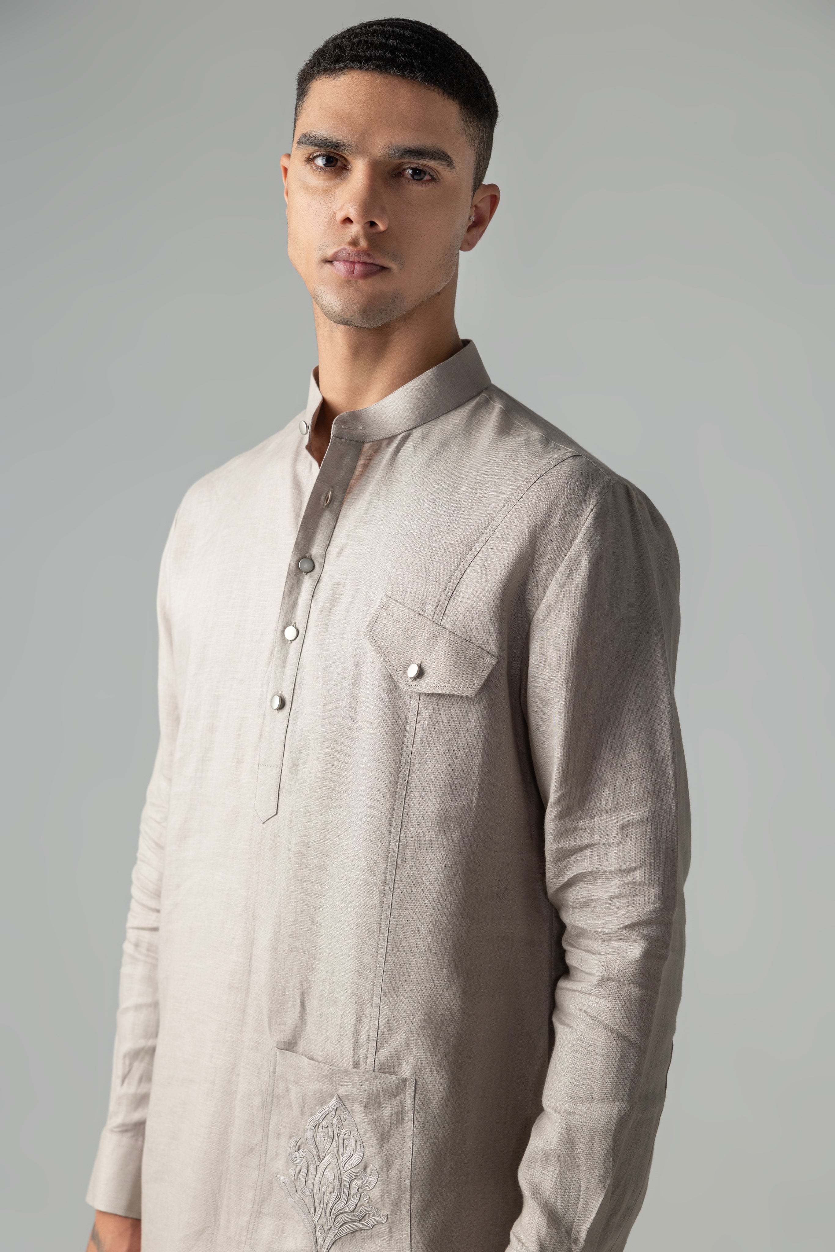 Beige short linen kurta with embroidered patch pocket detailing, paired with a matching plazzo